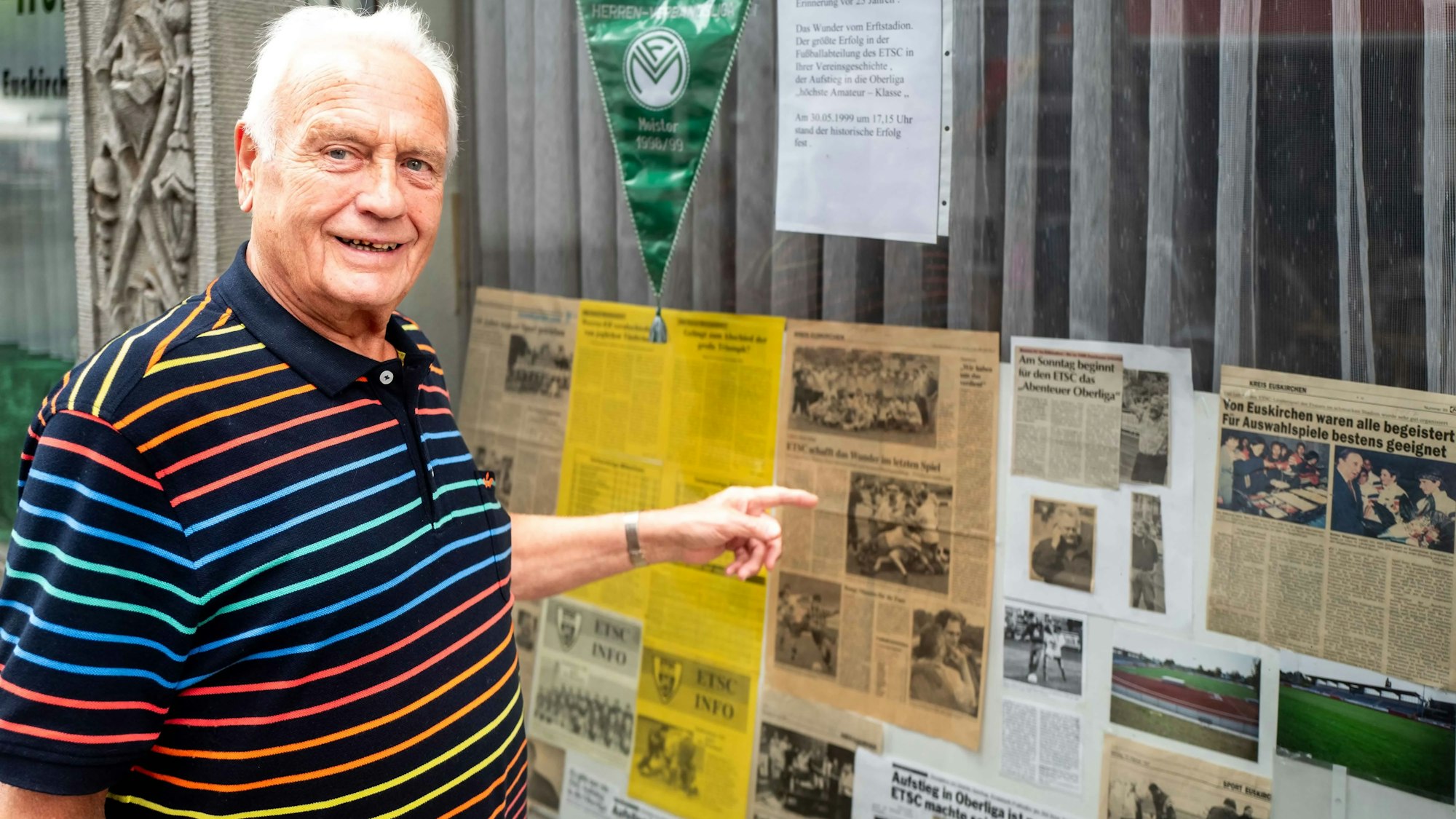 Ludwig Schnichels zeigt auf die ausgestellten Zeitungsartikel.