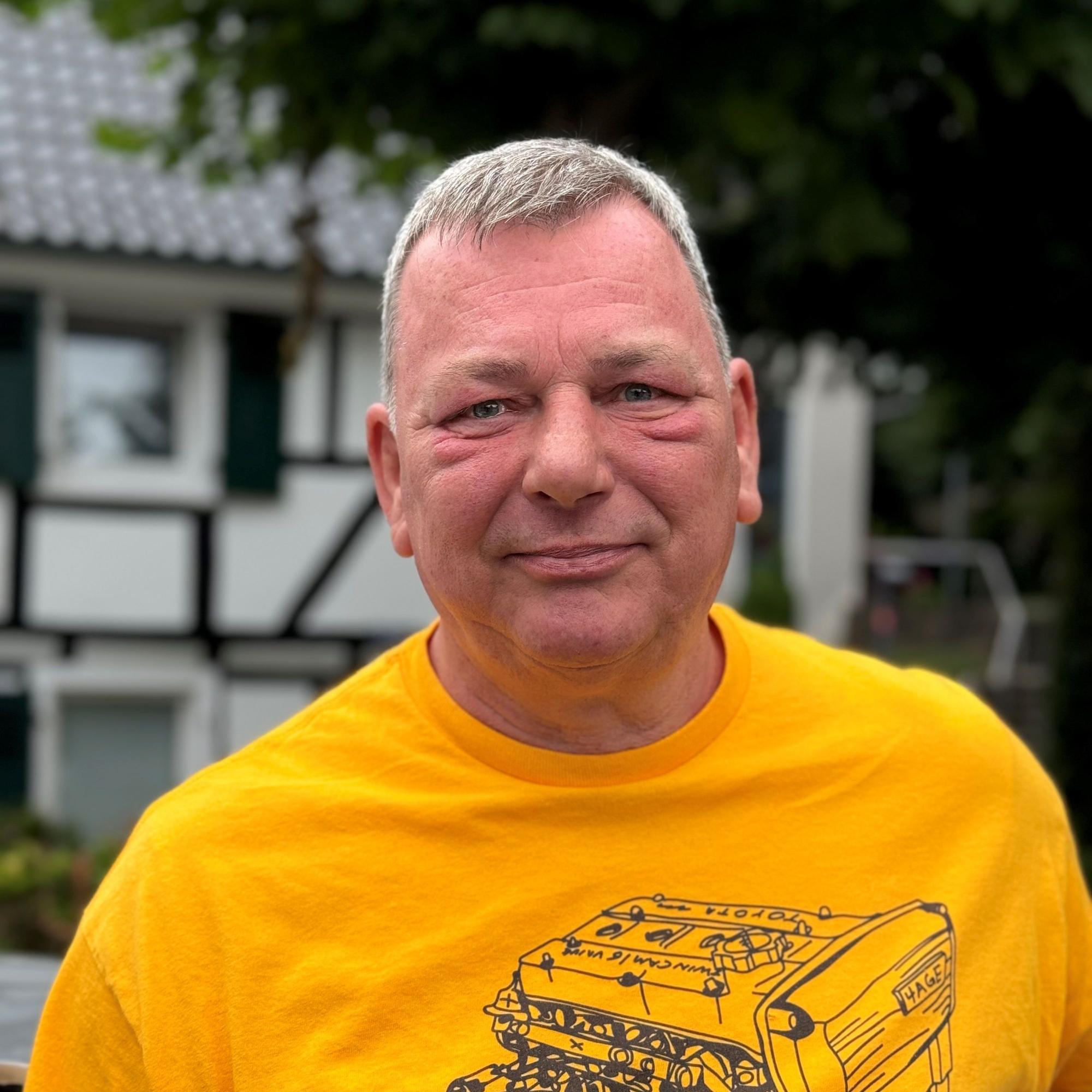 Olaf Brentzek aus Wipperfürth.schuat in die Kamera, er trägt ein gelbes T-Shirt.