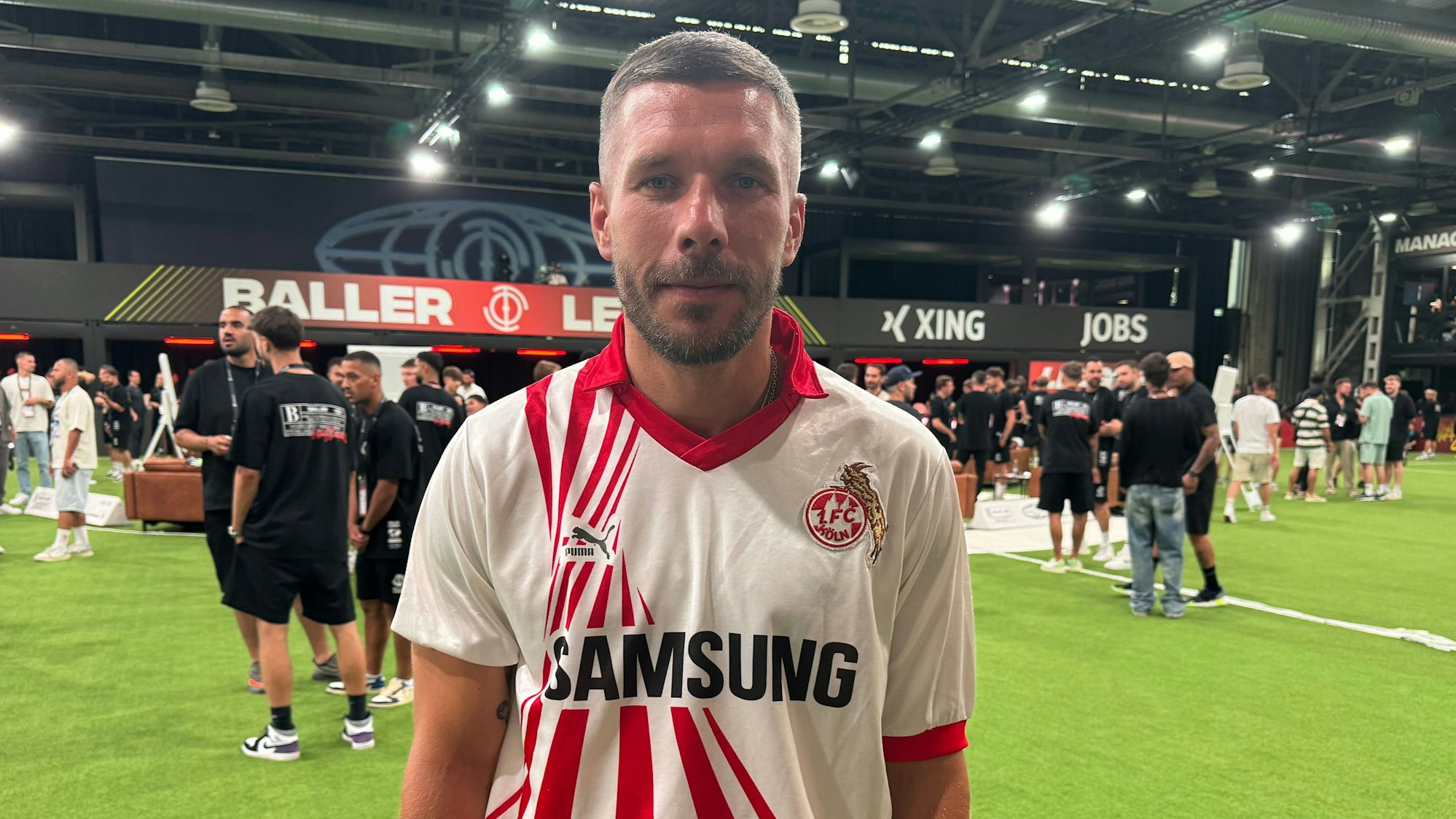 Lukas Podolski ist im Retro-Trikot seines Heimatklubs 1. FC Köln zu Besuch bei der Baller League in Ossendorf.