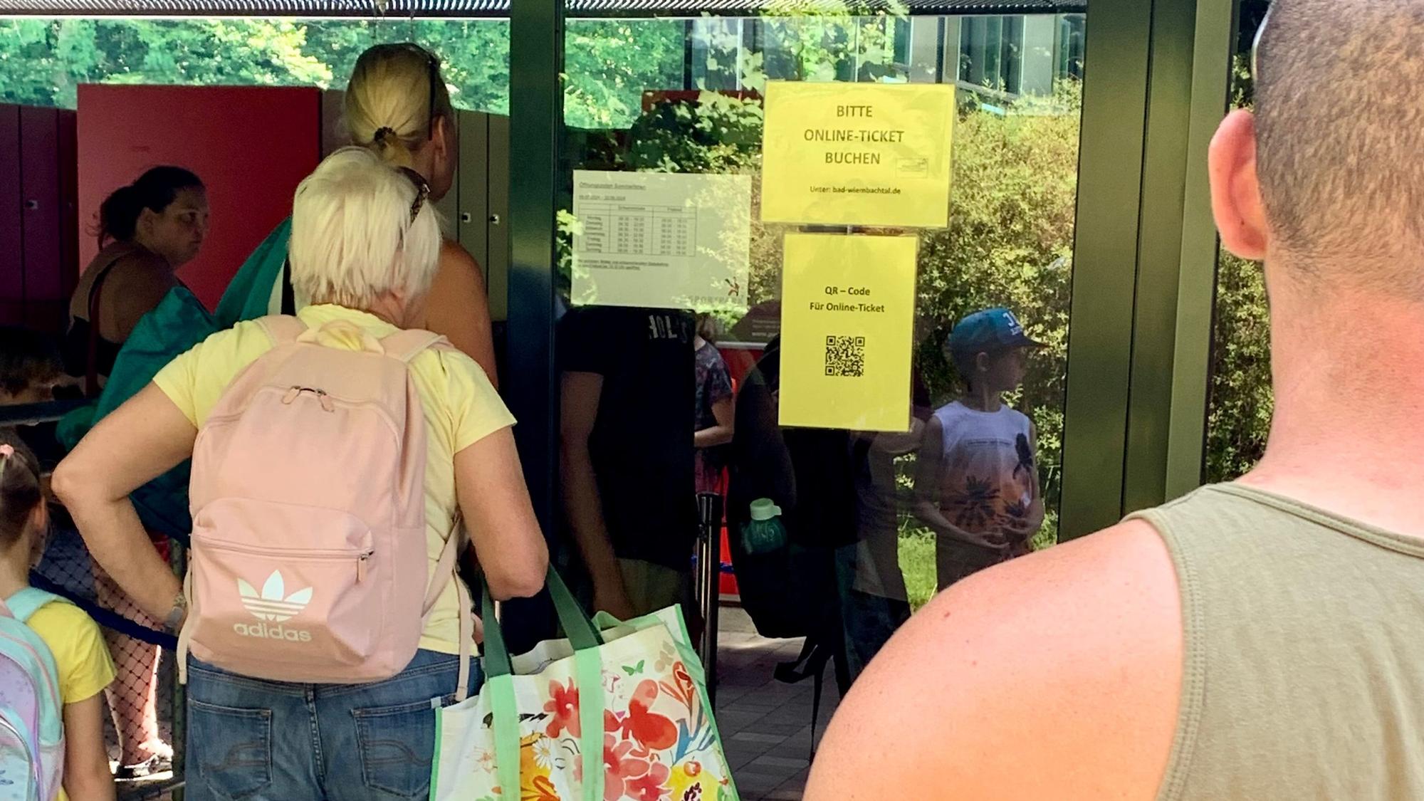 Menschen vor Freibad-Eingang