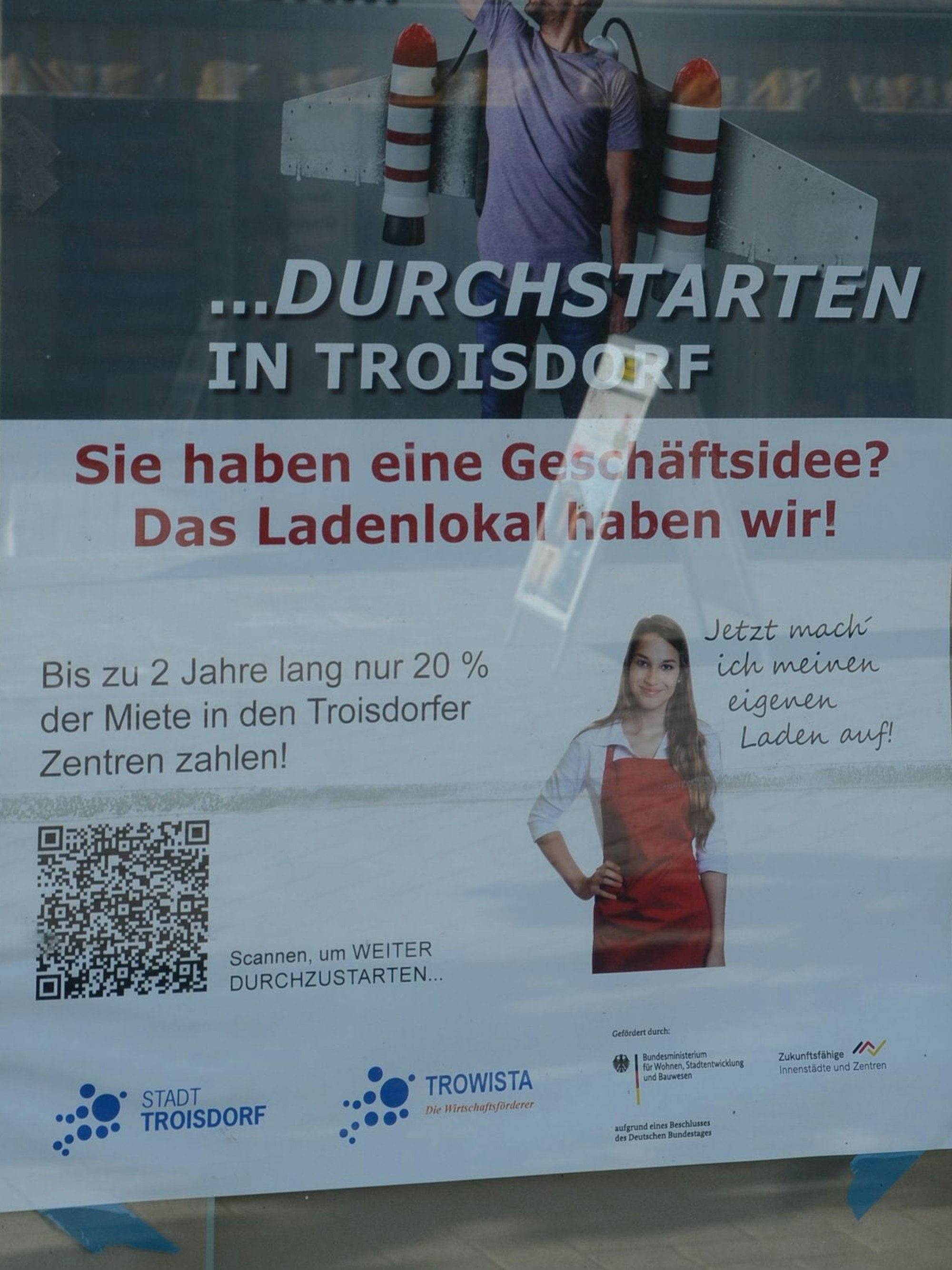 „Durchstarten in Troisdorf“ steht auf einem Plakat. Der Zusatz lautet:„ Sie haben eine Geschäftsidee?“ Wir haben das Ladenlokal dazu!