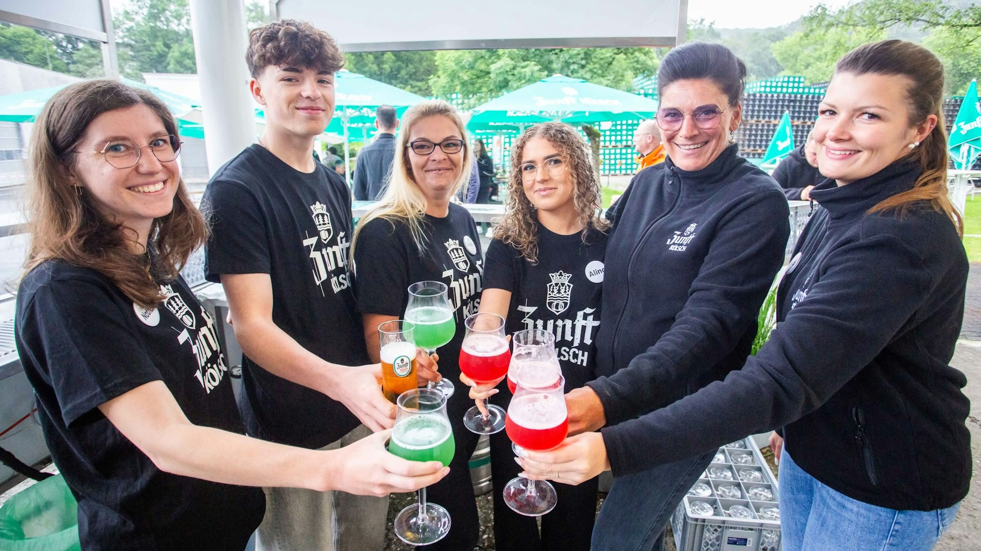 Mehrere junge Menschen stoßen mit Cocktails an.