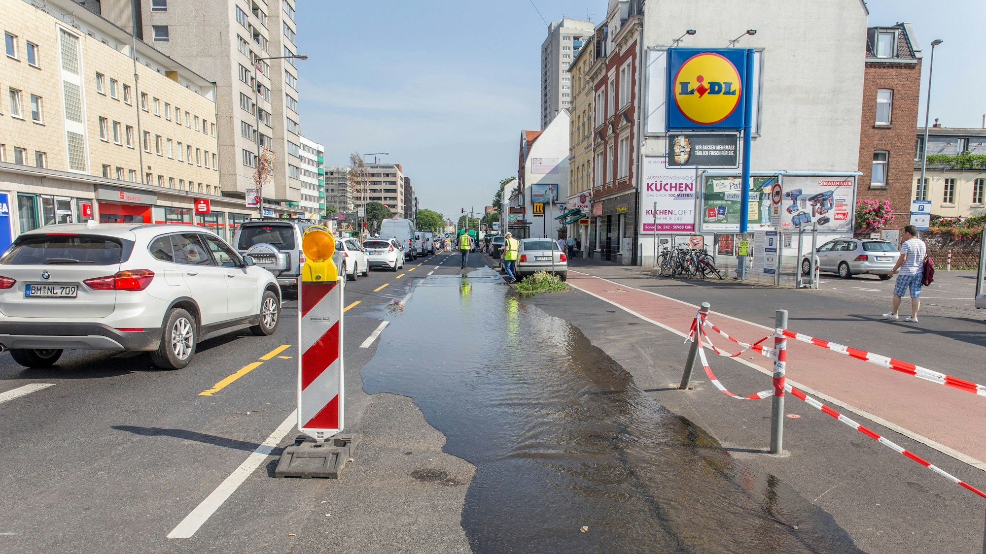 Auf einer Fahrbahn ist Wasser zu sehen, es ist auch einem Hydranten ausgetreten.