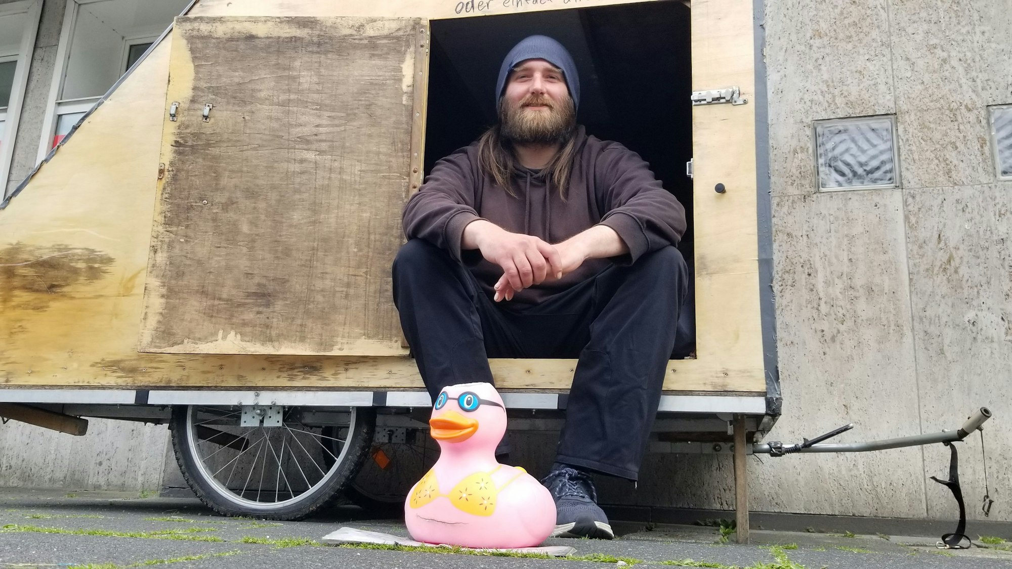 Jonathan sitzt in seiner Holzbox