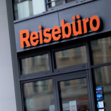 Ein Schild und Reisebüro der FTI-Group