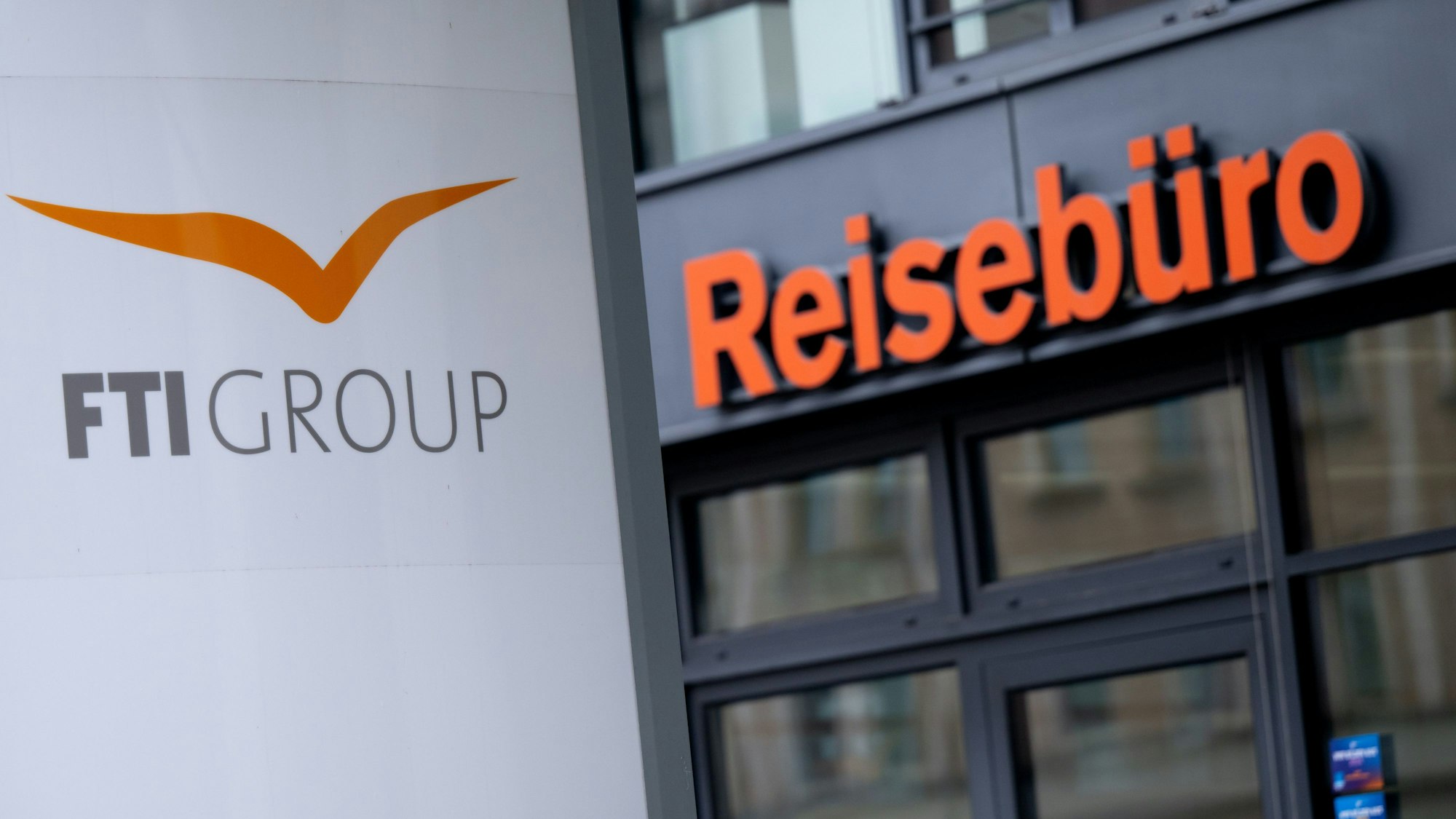 Ein Schild und Reisebüro der FTI-Group