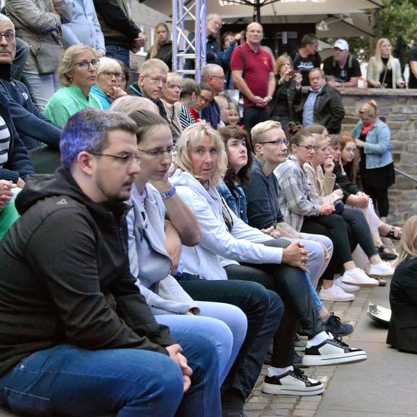 Zahlreiche Menschen sitzen gemeinsam mit Bürgermeisterin Sabine Preiser-Marian auf der Freitreppe zur Erft in Bad Münstereifel.