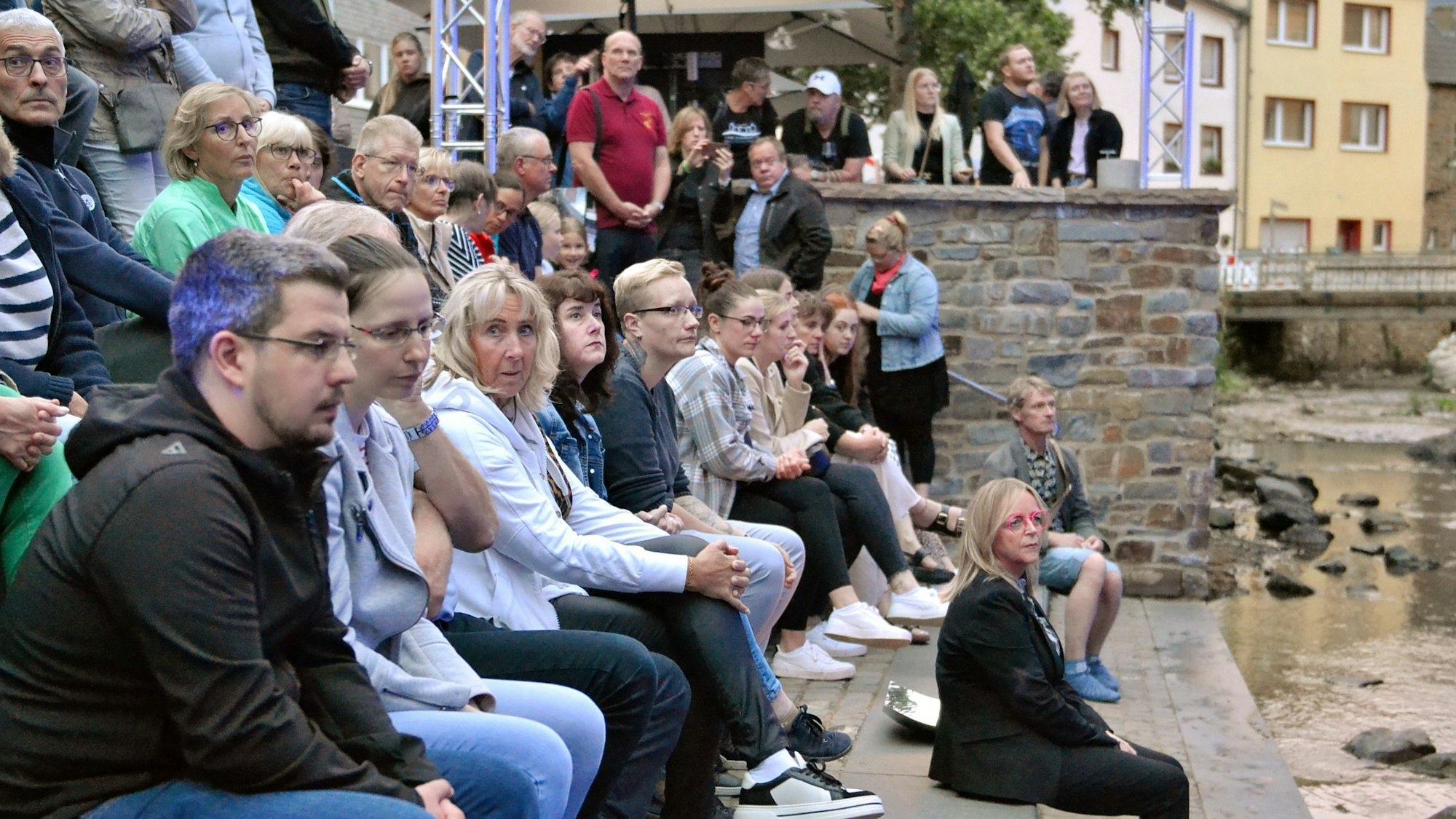 Zahlreiche Menschen sitzen gemeinsam mit Bürgermeisterin Sabine Preiser-Marian auf der Freitreppe zur Erft in Bad Münstereifel.