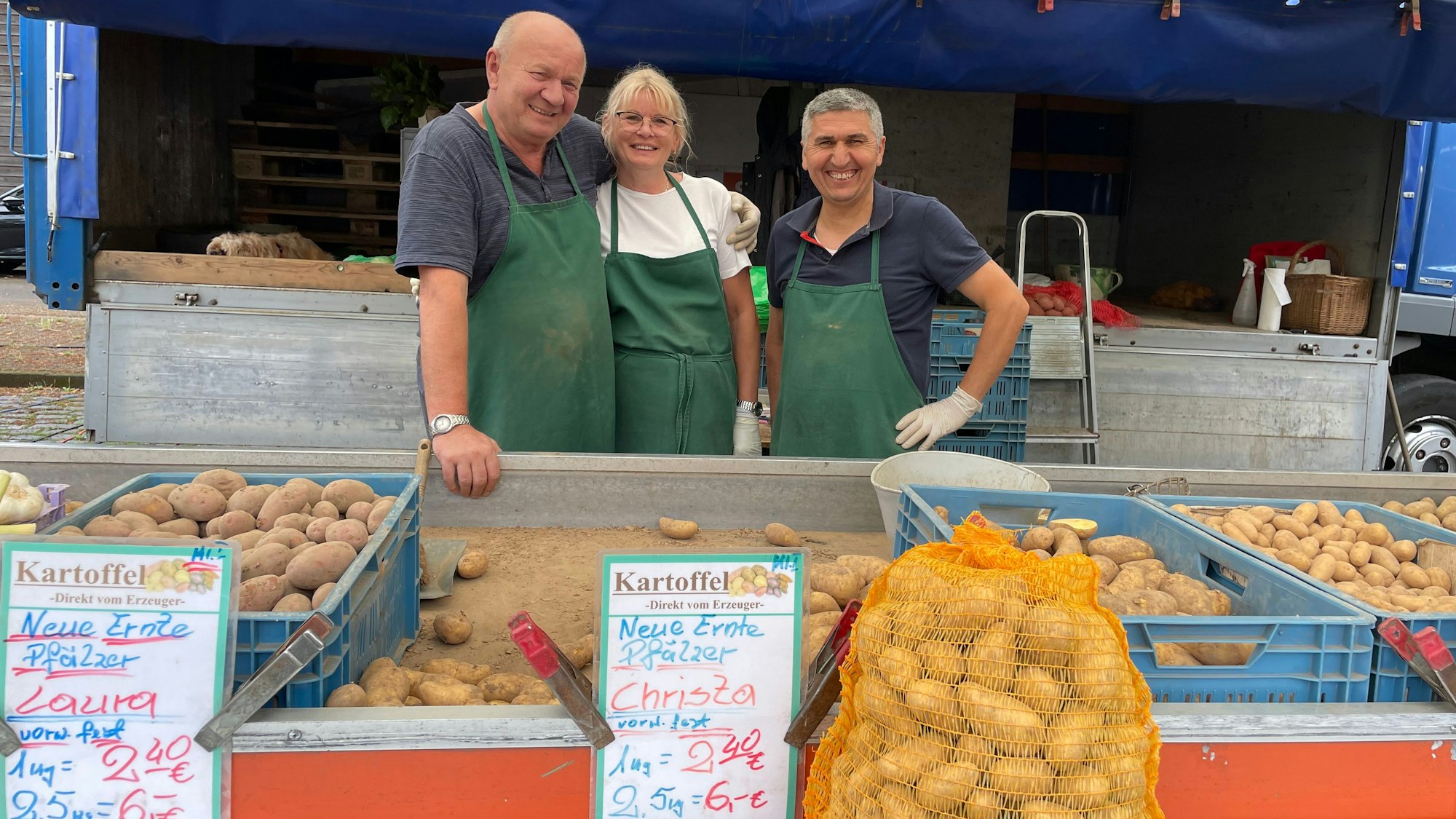 Witold Ulycer (v.l.) steht mit seiner Frau und seinem Nachfolger Akcay an dem Kartoffelstand auf dem Sürther Wochenmarkt.