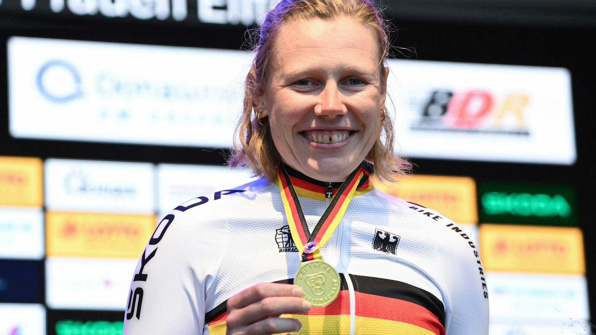 21.06.2024, Baden-Württemberg, Donaueschingen/Bad Dürrheim: Radsport: Deutsche Meisterschaft, Donaueschingen - Bad Dürrheim, Zeitfahren Frauen: Die Siegerin Mieke Kröger vom RV Teuteburg Brackwede zeigt bei der Siegerehrung ihre Goldmedaille. Foto: Bernd Weißbrod/dpa +++ dpa-Bildfunk +++