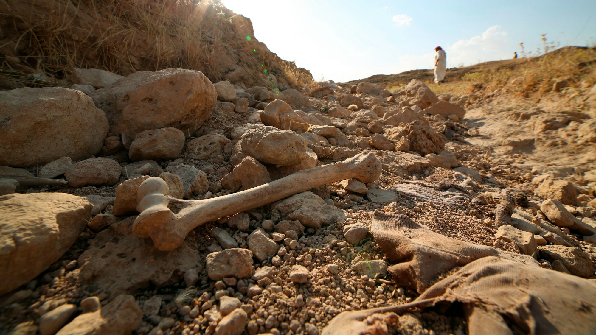 Knochen und Stoffreste liegen in einem Massengrab, in dem Opfer der Terrororganisation Islamischer Staat (IS), liegen.