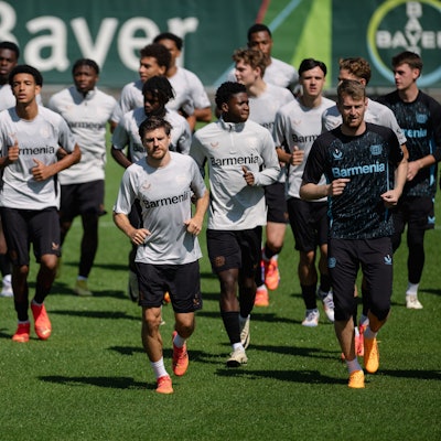 Trainingsauftakt bei Bayer 04 Leverkusen. Die Mannschaft läuft sich warm. Vorneweg laufen Edmond Tapsoba (l-r), Jonas Hofmann und Torhüter Lukas Hradecky.