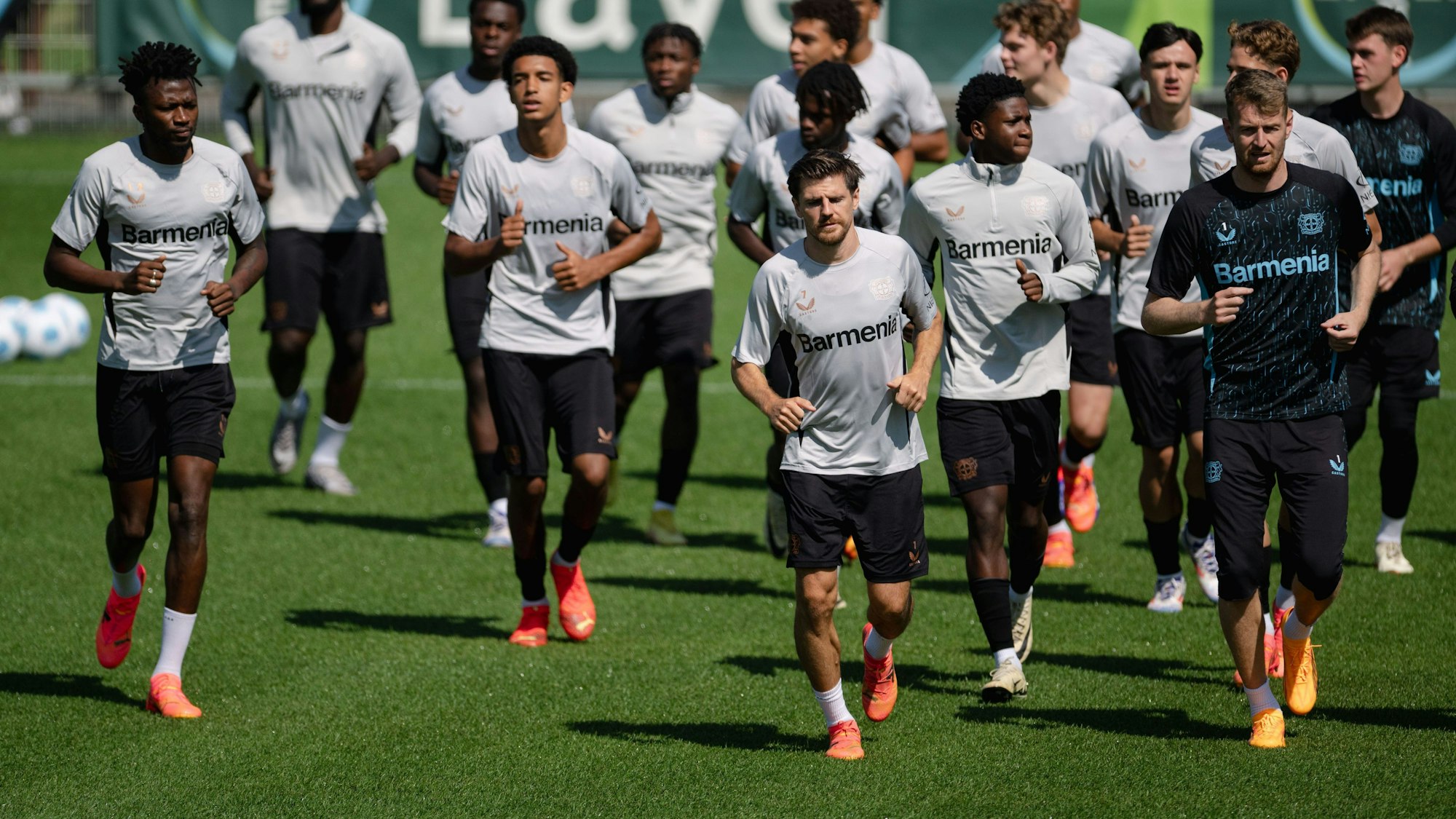 Trainingsauftakt bei Bayer 04 Leverkusen. Die Mannschaft läuft sich warm. Vorneweg laufen Edmond Tapsoba (l-r), Jonas Hofmann und Torhüter Lukas Hradecky.