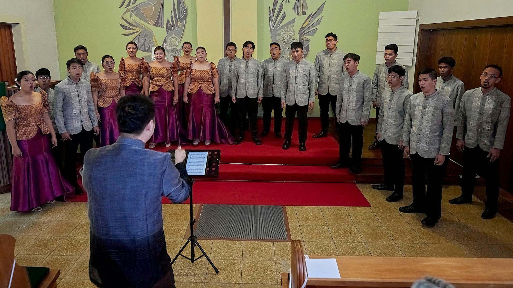 Die Sängerinnen und Sänger des philippinischen Chor Imusicapella stehen im Altarraum der Evangelischen Kirche in Blankenheim und singen.
