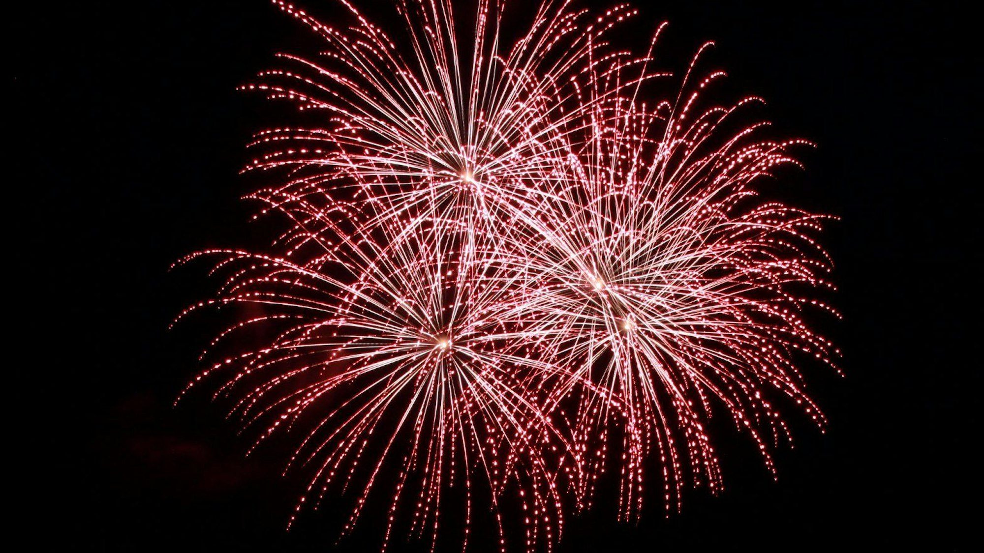 Feuerwerkskörper explodieren am Nachthimmel.