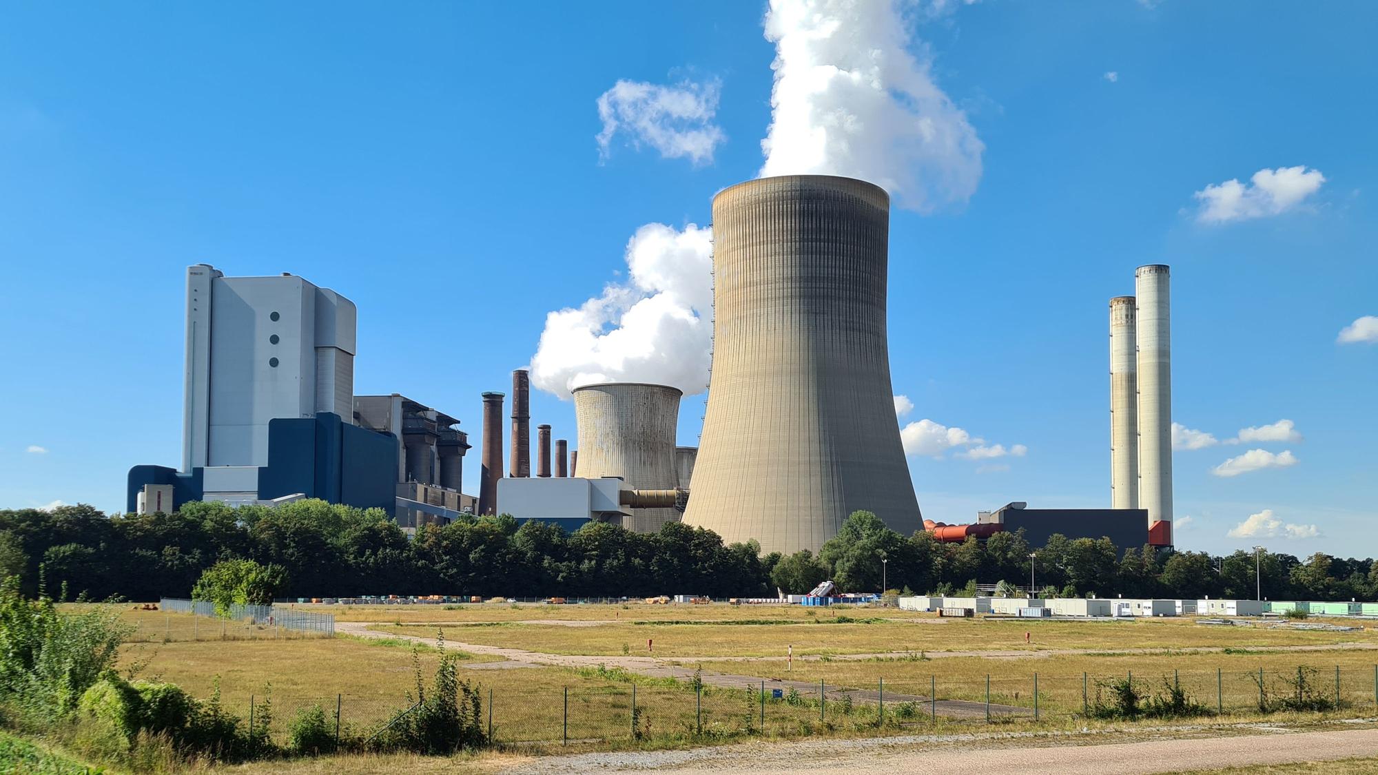 Das Bild zeigt eine große brachliegende Fläche vor dem Kraftwerk Niederaußem.