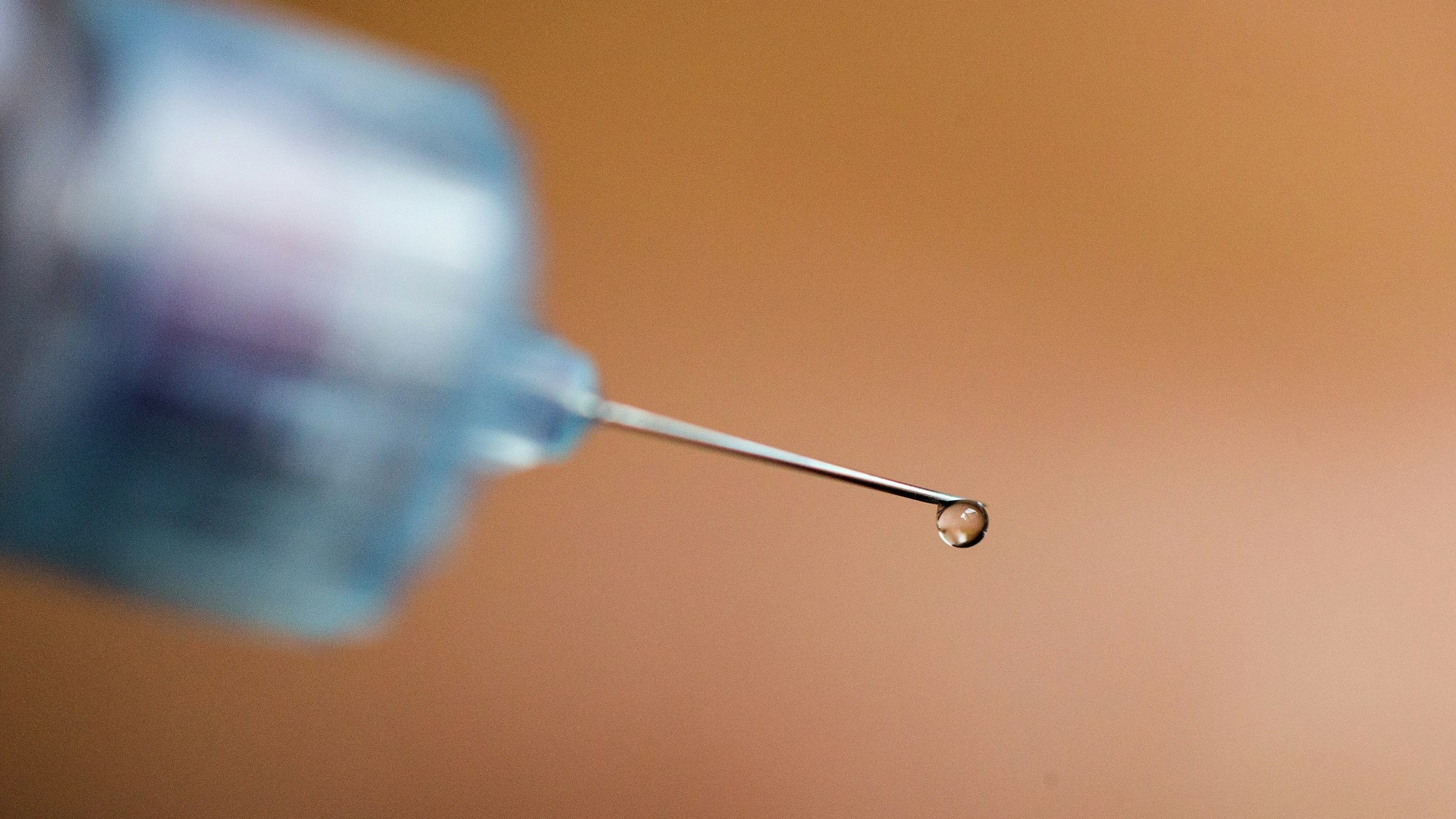 Ein Tropfen Insulin hängt an der Nadelspitze eines Pen.