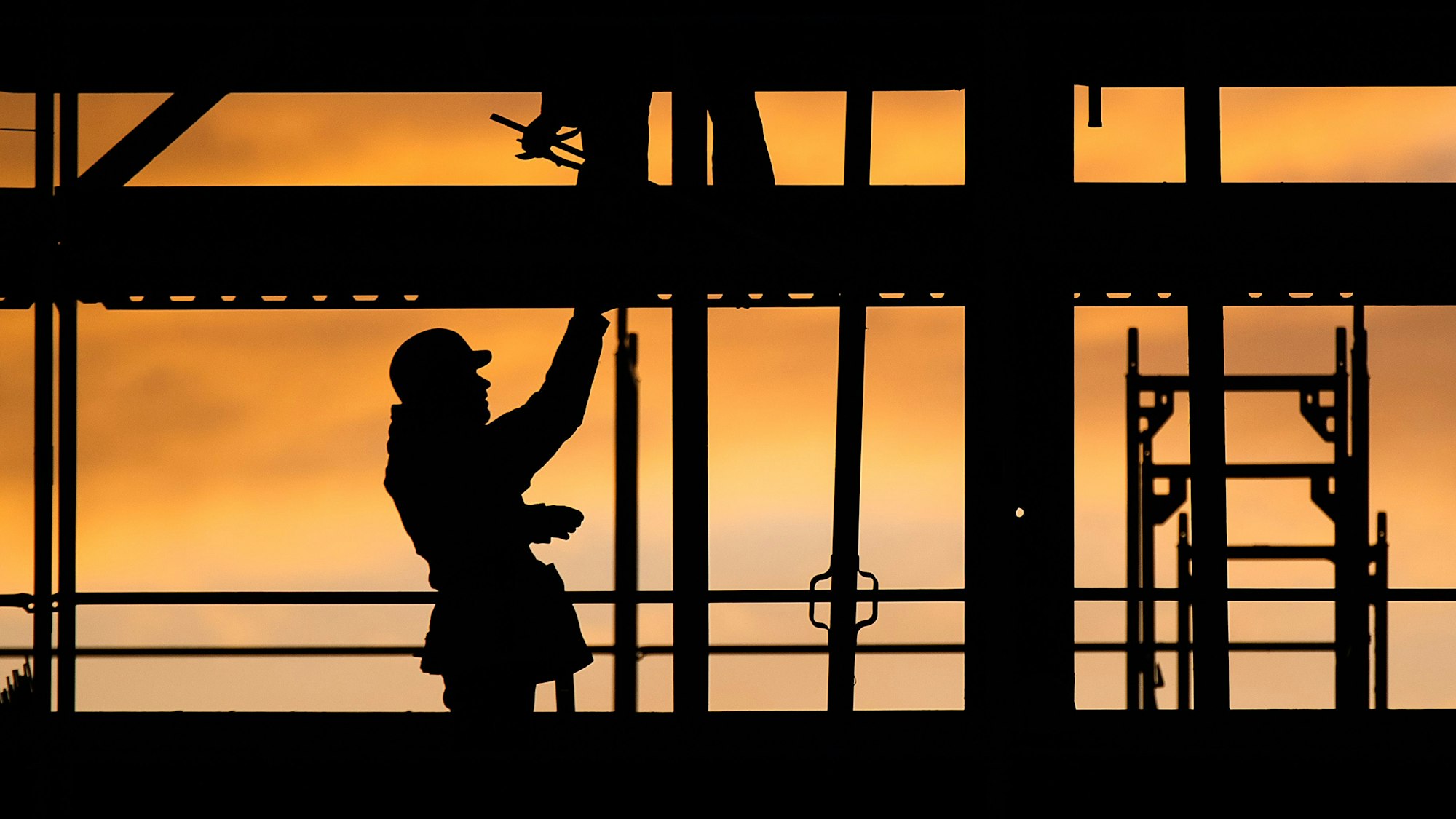 Bauarbeiter errichten bei Sonnenaufgang ein Gebäude.