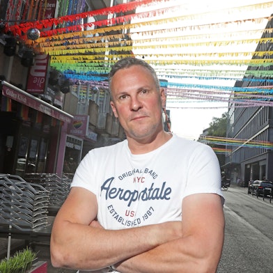 Matthias Eiting steht auf der für den CSD geschmückten Schaafenstraße.