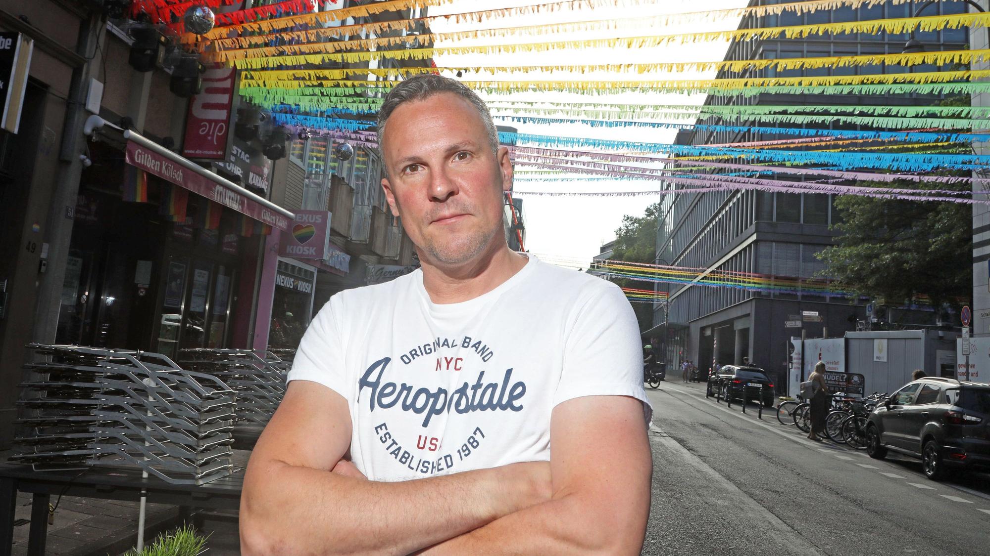 Matthias Eiting steht auf der für den CSD geschmückten Schaafenstraße.