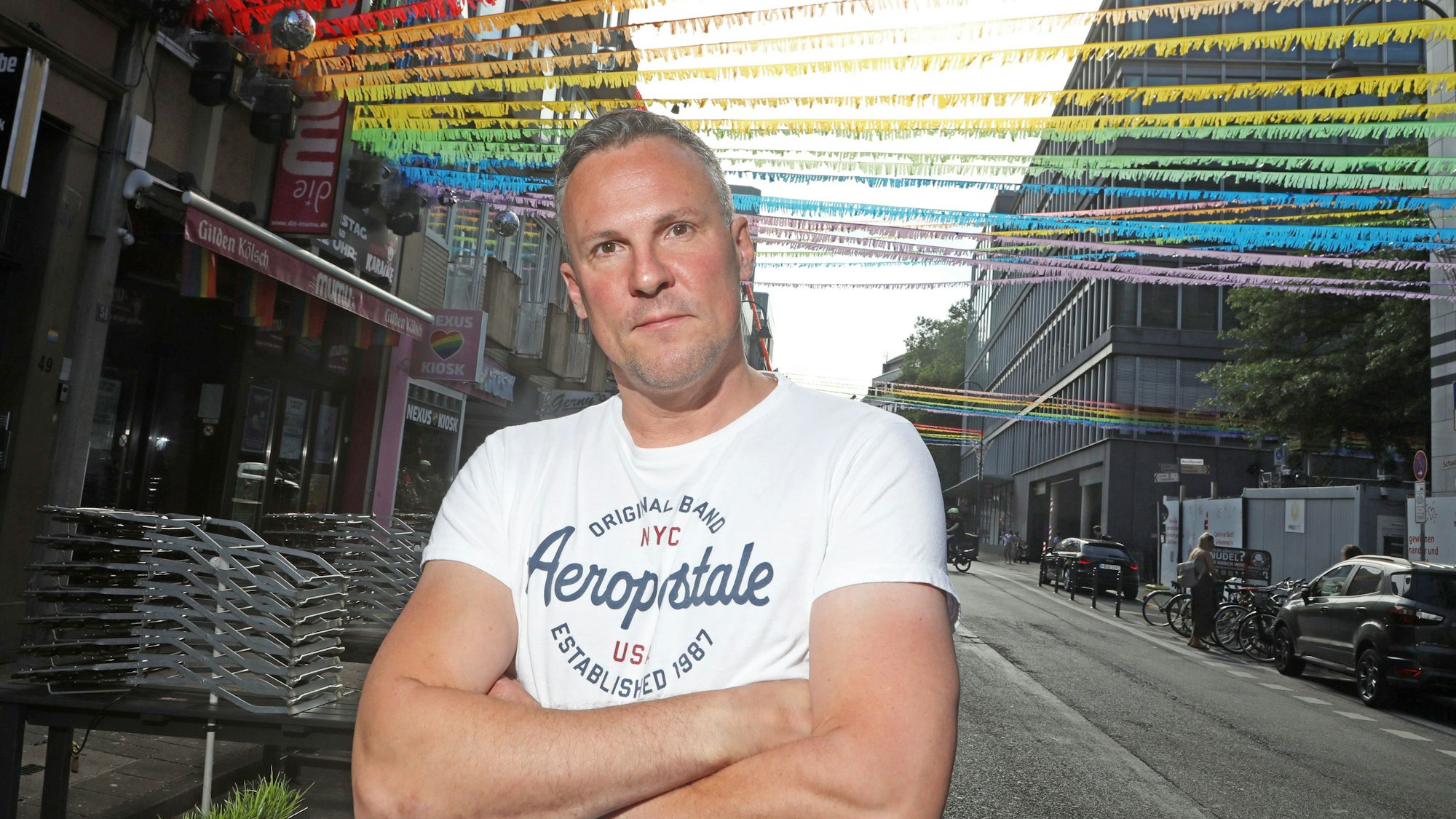 Matthias Eiting steht auf der für den CSD geschmückten Schaafenstraße.