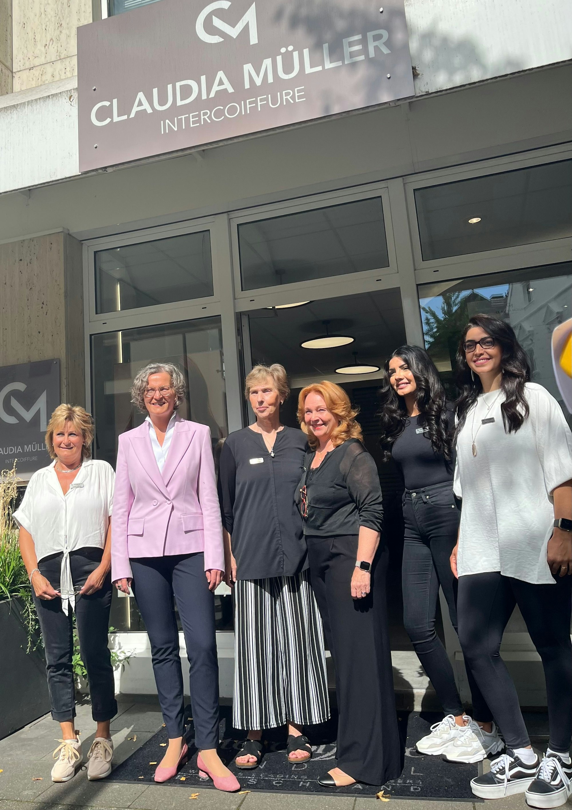 Gruppe von Frauen vor Frisörsalon