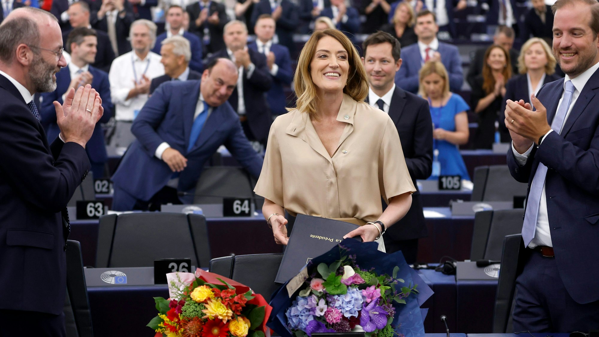 Die Präsidentin des Europäischen Parlaments, Roberta Metsola (Mitte), erhält Blumen während der Eröffnungssitzung des neu gewählten Europäischen Parlaments in Straßburg, Ostfrankreich, am Dienstag, 16. Juli 2024.