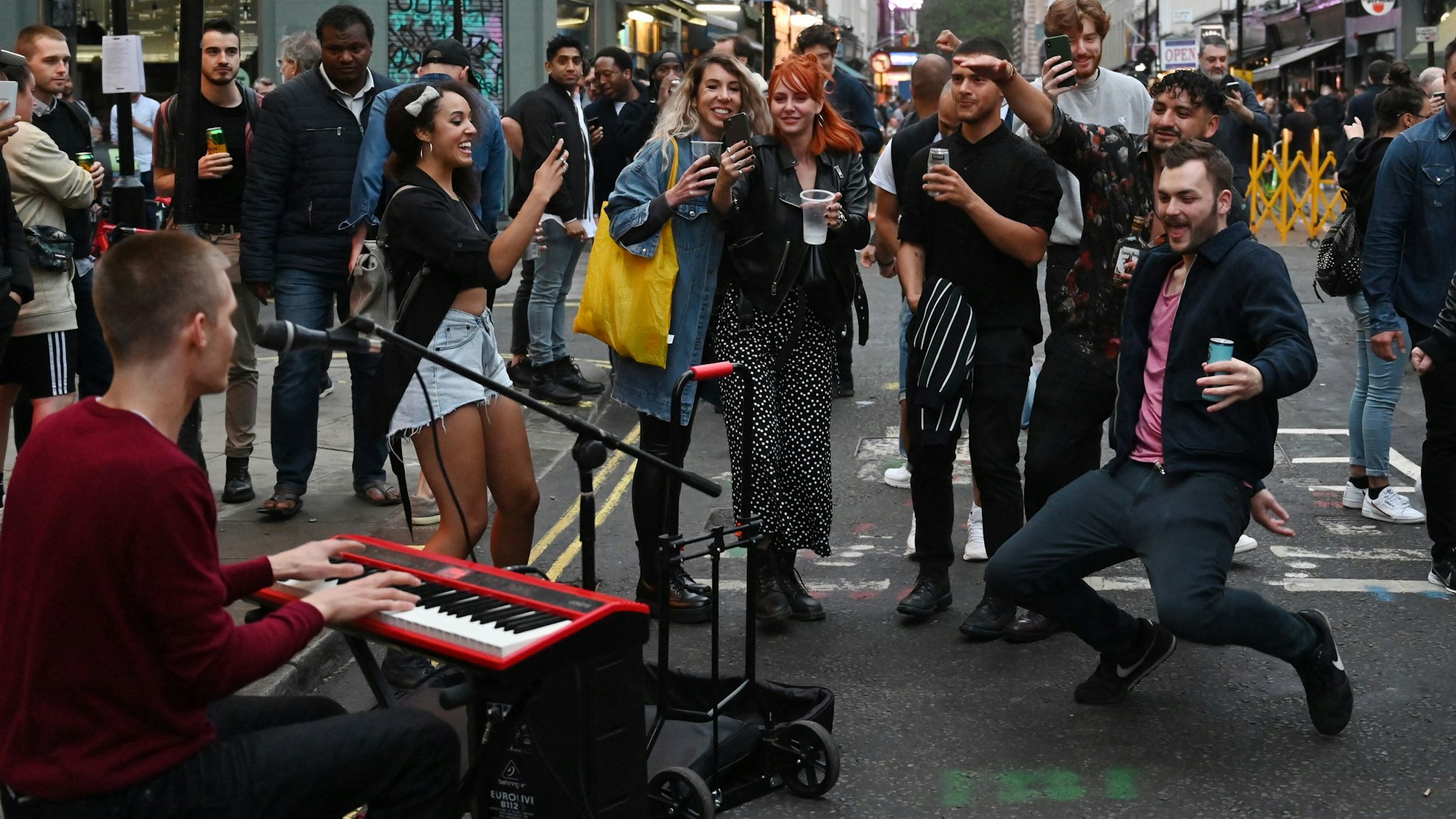 Menschen tanzen in London zur Straßenmusik.
