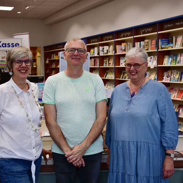 Ein Mann und zwei Frauen stehen in einer Buchhandlung.