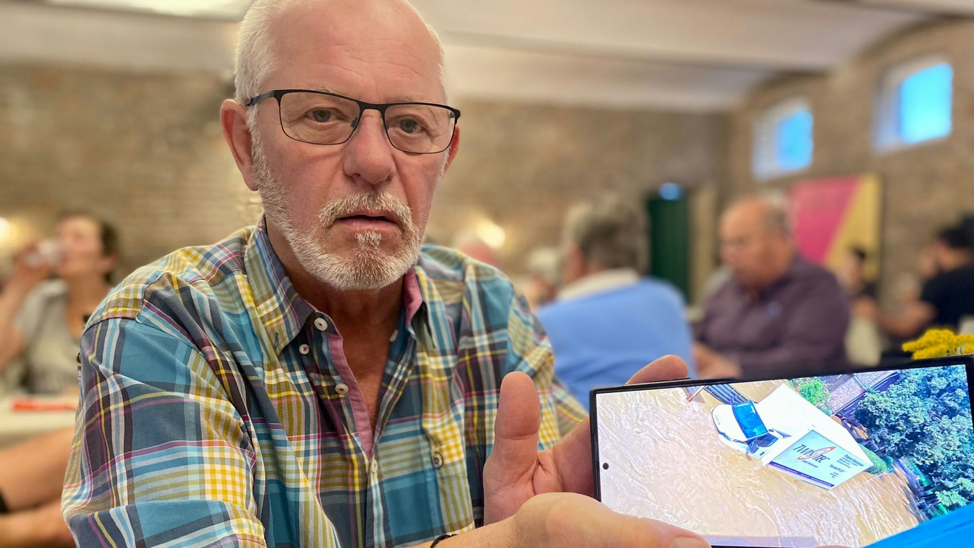 Ein Mann zeigt Bilder auf seinem Handy.