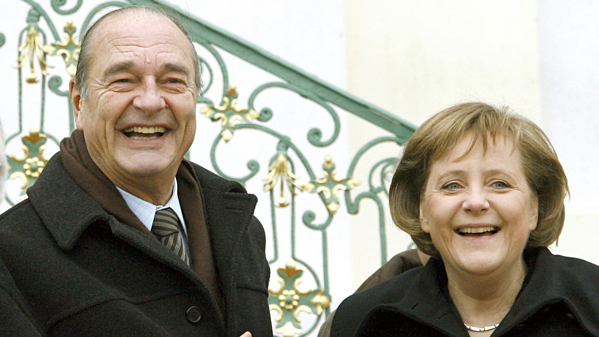 Winkend zeigen sich der damalige französische Staatspräsident Jacques Chirac und Angela Merkel vor dem Gästehaus der Bundesregierung in Meseber.