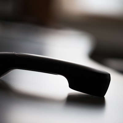 Zu sehen ist ein abgelegter Telefonhörer.