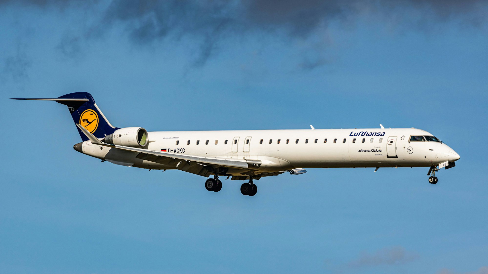 Eine Bombardier CRJ-900 der deutschen Fluggesellschaft Lufthansa fliegt unter einer Unwetterwolke hinweg. (Symbolbild)