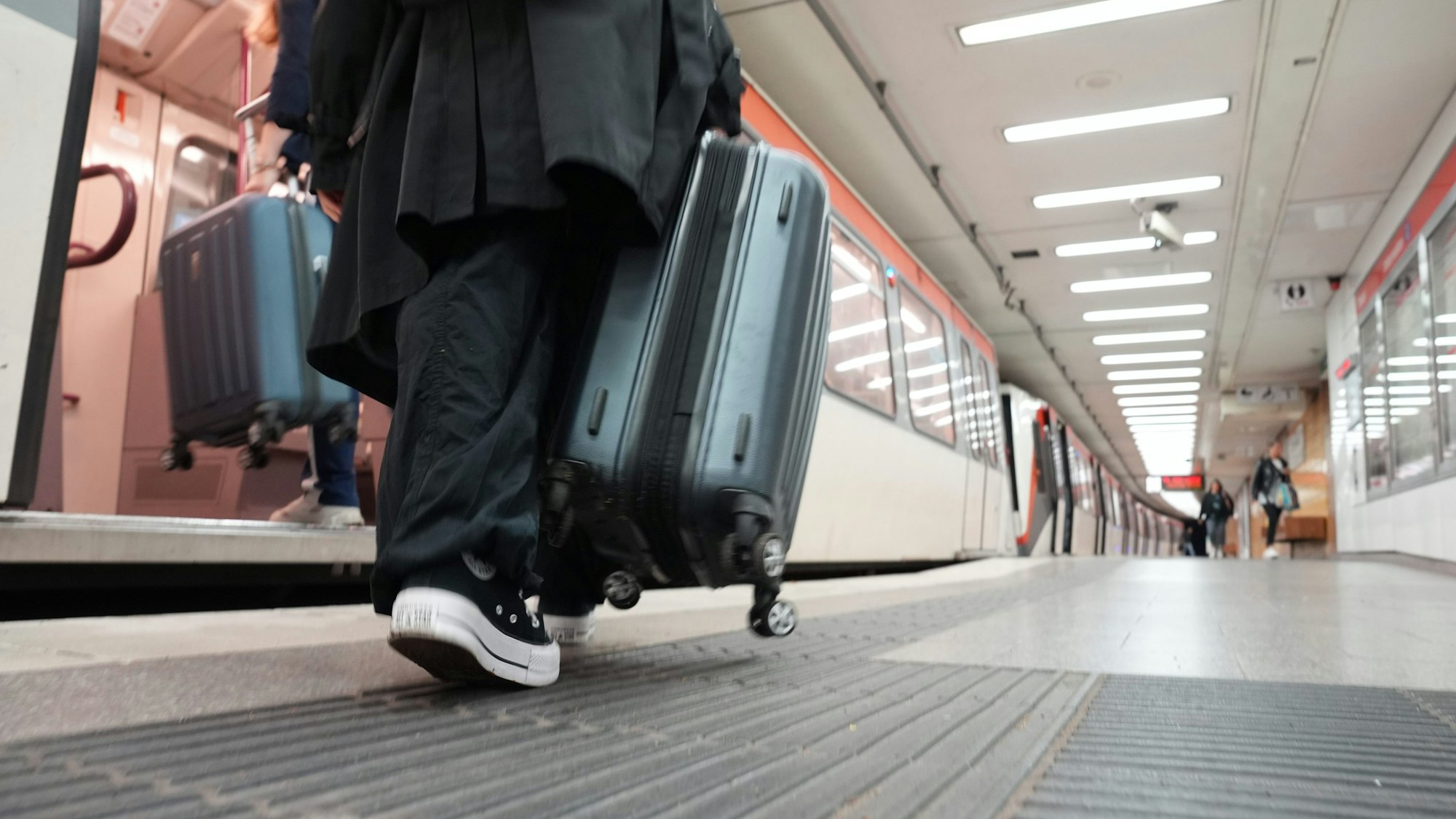 Fahrgäste steigen an einer U-Bahnstation mit ihrem Gepäck in eine U-Bahn.