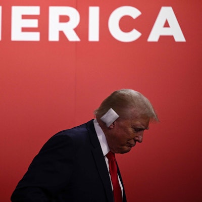 Donald Trump steht vor dem Schriftzug „America“