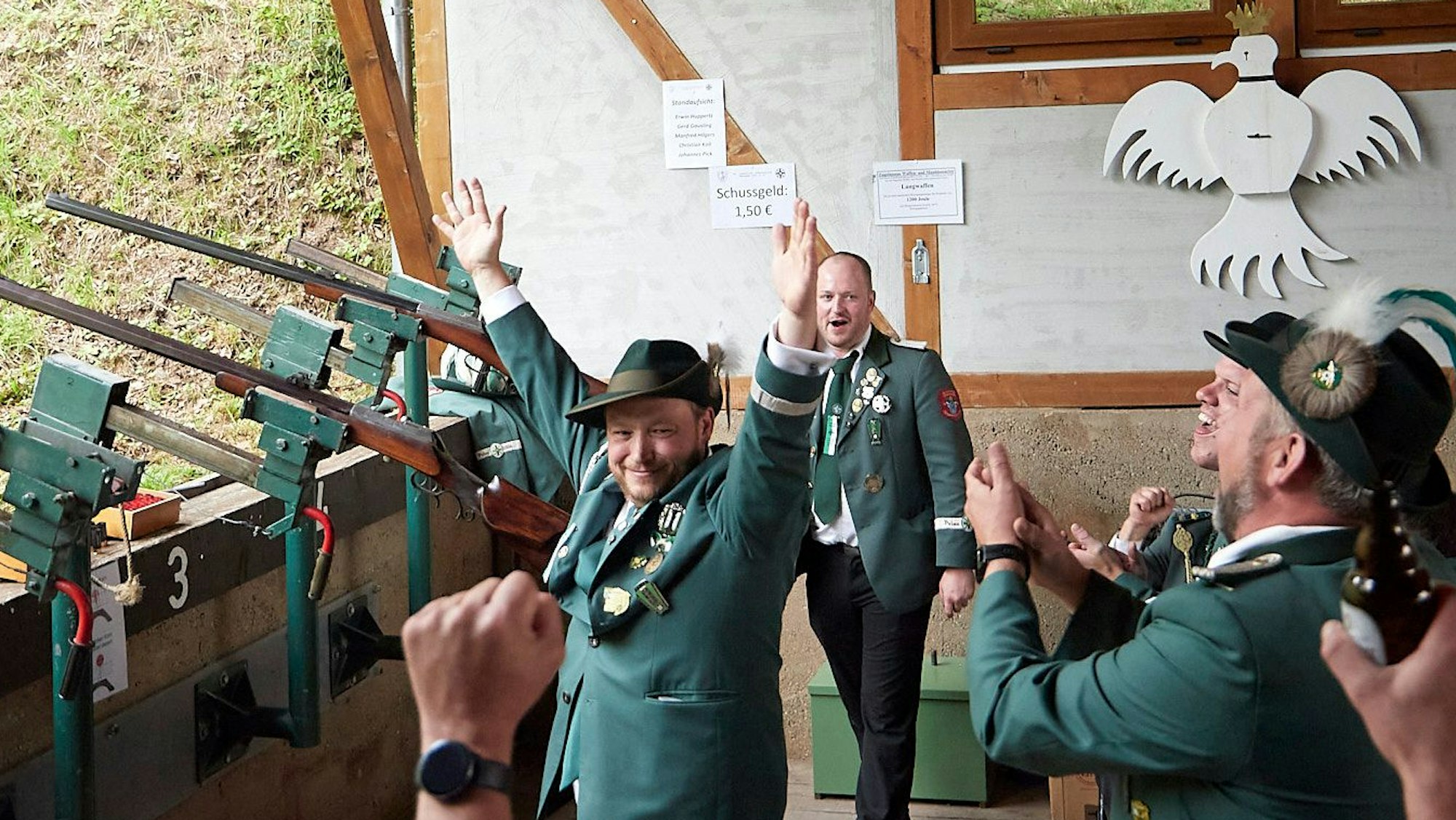 Johannes Pick reißt die Hände in die Höhe, weil er gerade Schützenkönig in Marmagen geworden ist. Um ihn herum stehen weitere Schützen und applaudieren.
