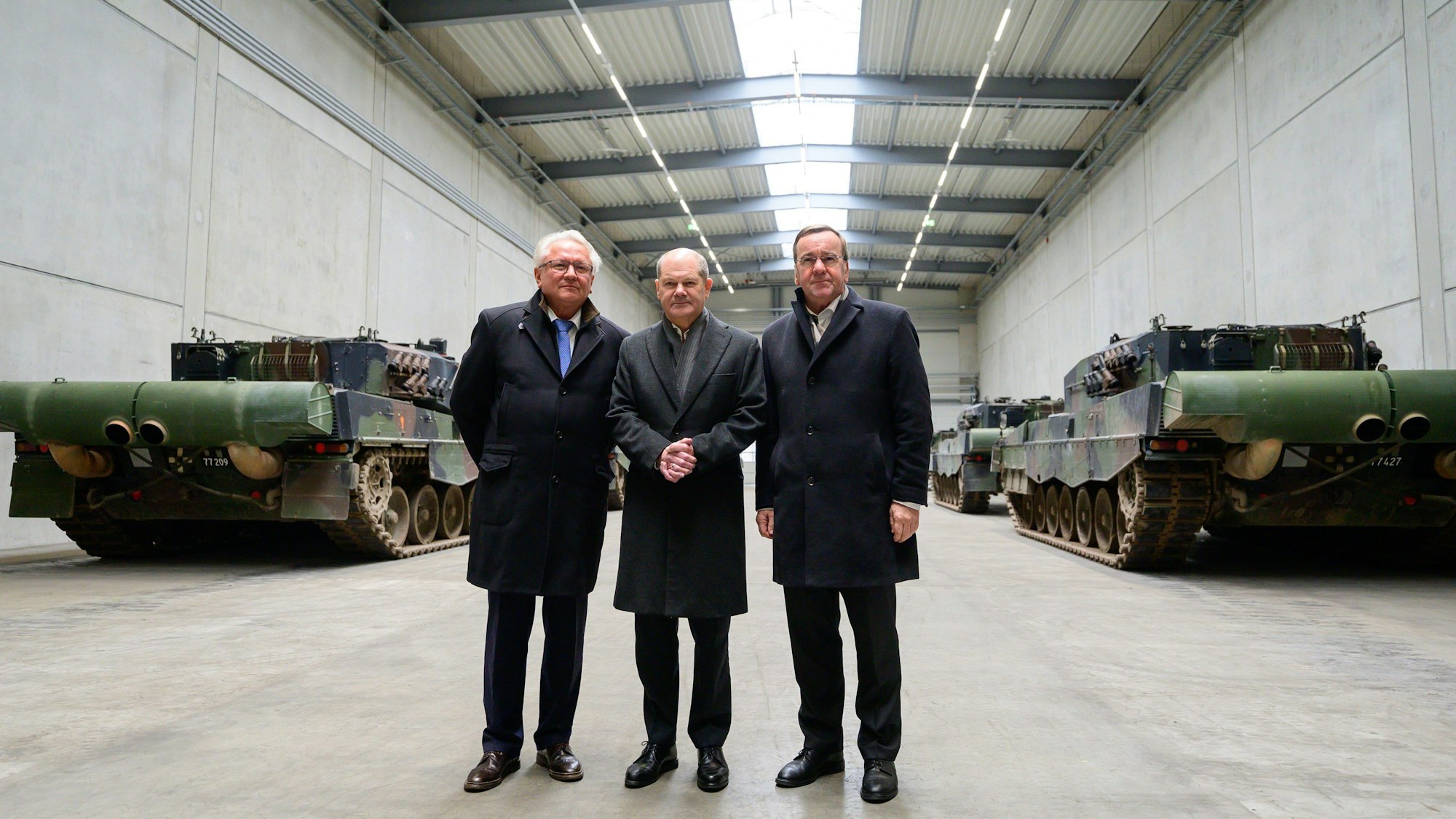 Armin Papperger (l-r), Vorstandsvorsitzender der Rheinmetall, Bundeskanzler Olaf Scholz (SPD), und Boris Pistorius (SPD), Bundesminister für Verteidigung, stehen in einer Halle mit Kampfpanzern vom Typ Leopard 2A4. Mit dem symbolischen Spatenstich auf dem Gelände von Rheinmetall wurde an dem Tag der Bau einer neuen Munitionsfabrik der Rheinmetall beginnen. In der Munitionsfabrik sollen Artilleriemunition, Explosivstoffe und Raketenartillerie produziert werden. Ein CNN-Bericht über angebliche russische Anschlagspläne gegen Rheinmetall-Chef Armin Papperger sorgt in Deutschland für Entrüstung.