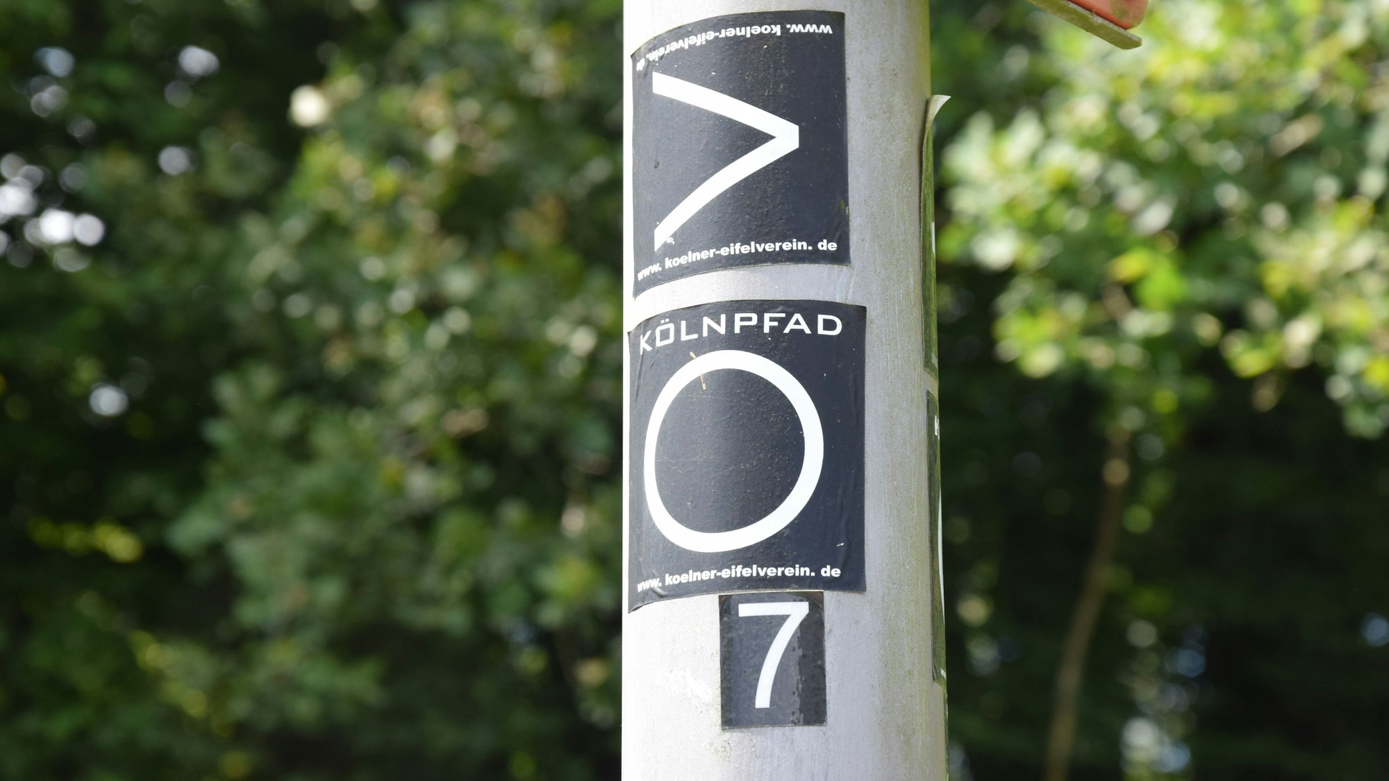 An einer Laterne sind Strecken-Aufkleber geklebt.