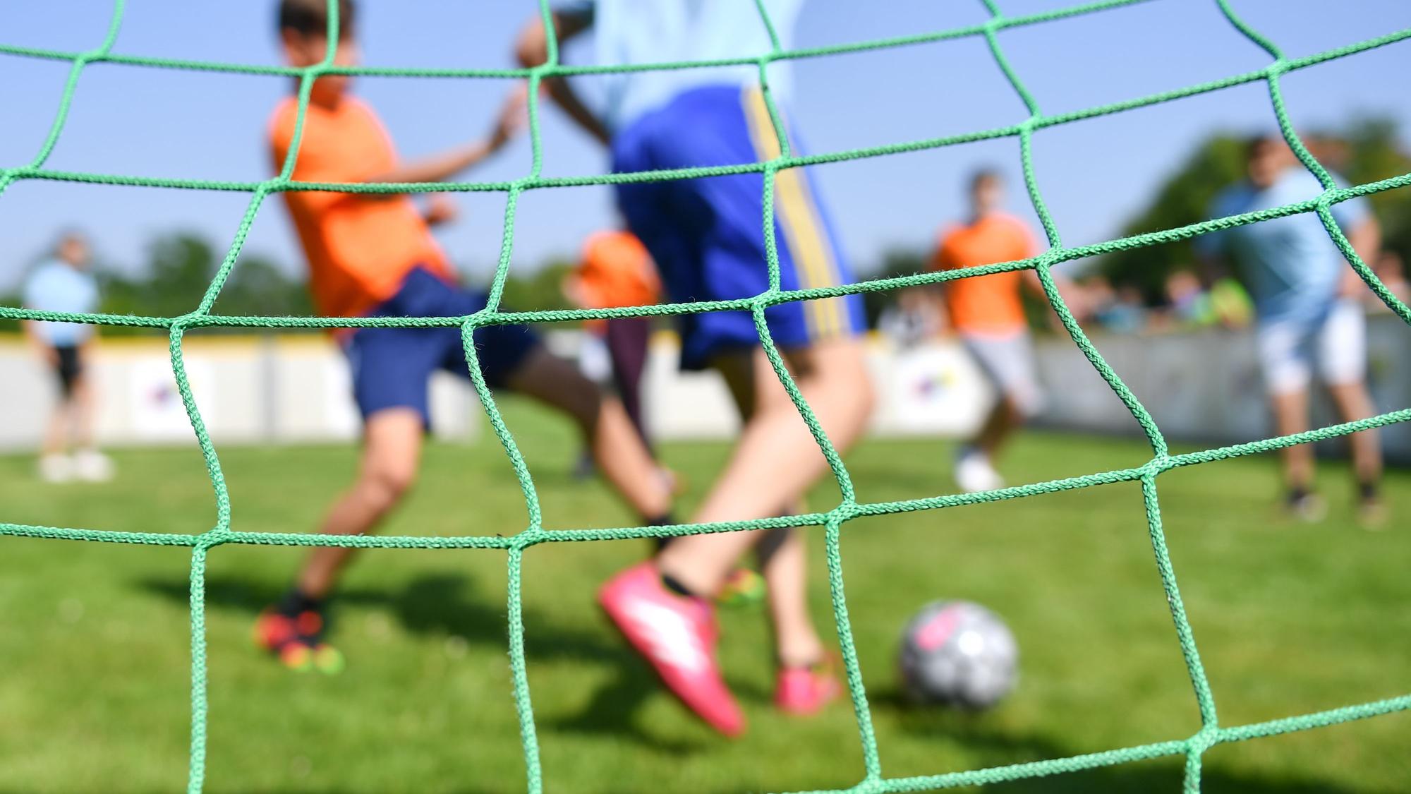 Kinder spielen auf einem Sportplatz.