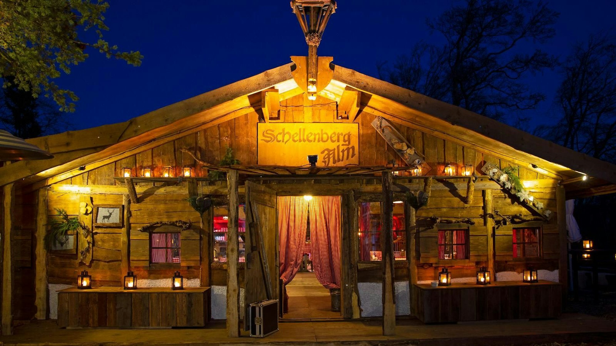 Eine Almhütte von außen, ist im Dunkeln beleuchtet.