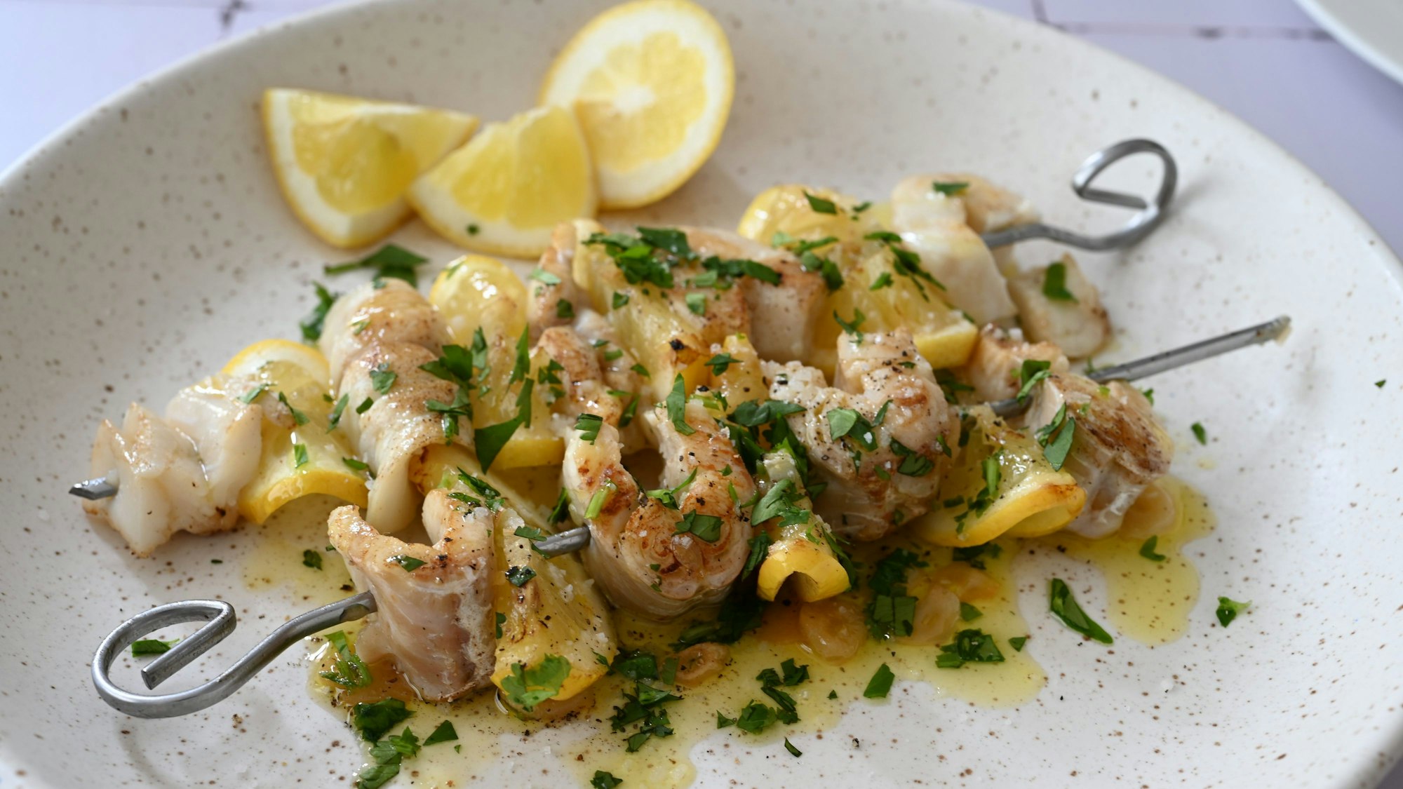 Fischstückchen und gefaltete Zitronenscheibchen sind abwechselnd aufgespießt.