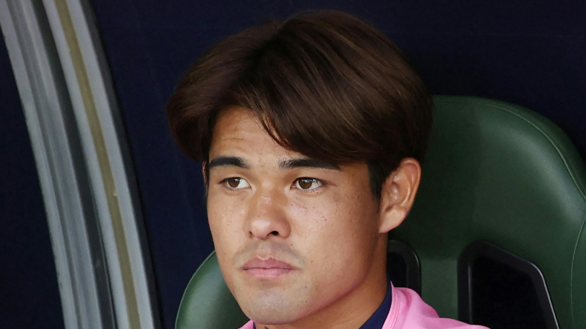 Kaishu Sano sitzt auf der Bank abseits des Fußballfelds.