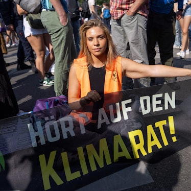 Klima-Aktivistin Anja Windl hält ein Banner mit der Aufschrift «Hört auf den Klimarat».