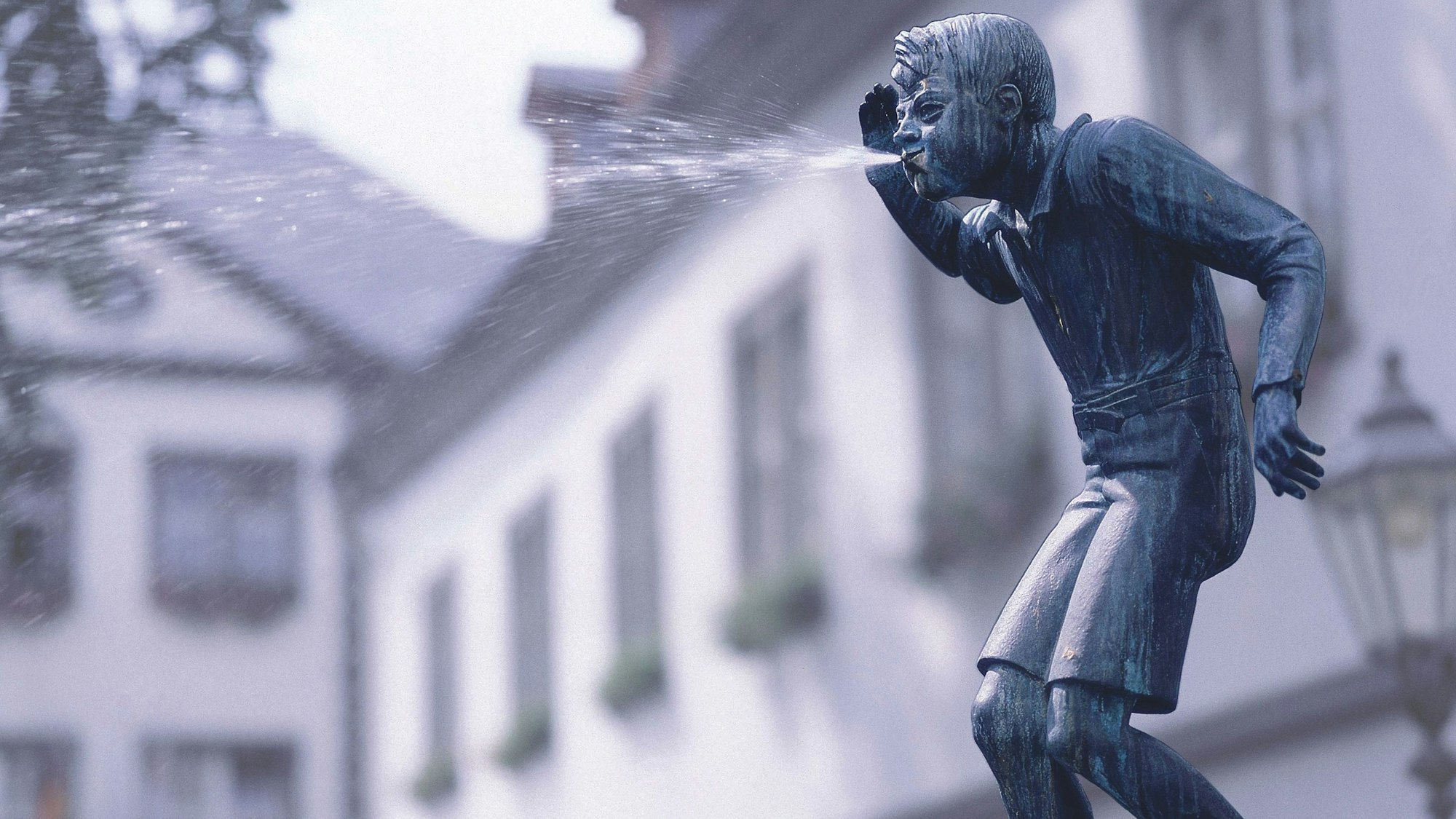 Der Schängel spuckt von der Spitze seines Brunnens über das Brunnenbecken.
