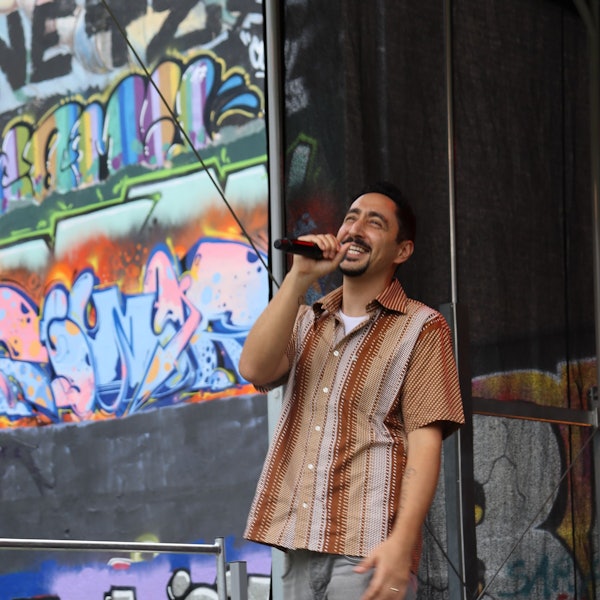 Zu sehen ist Eko Fresh mit Mikrofon in der Hand auf einer Bühne.