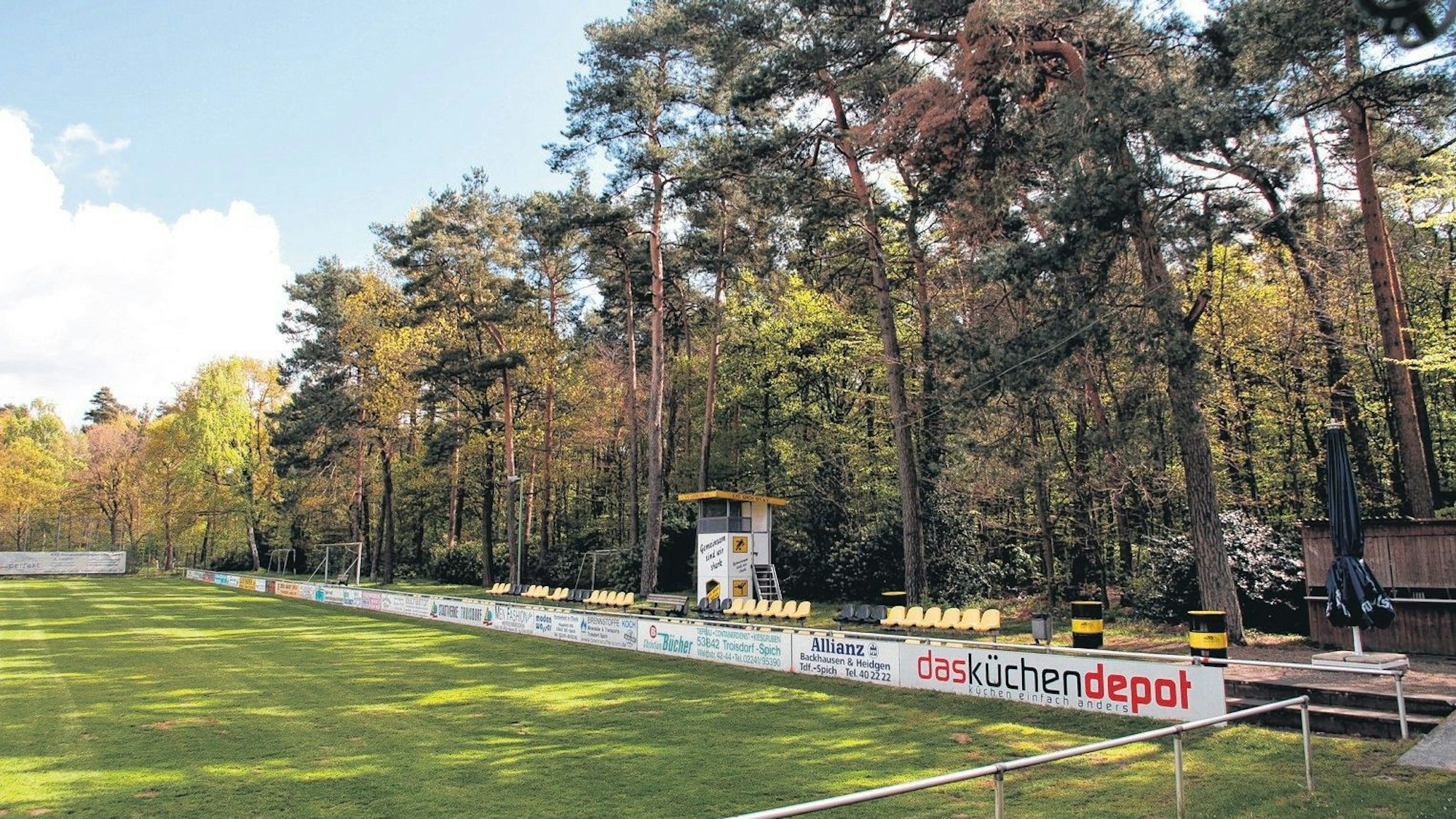 Ein Fußballplatz am Rand eines Waldes.