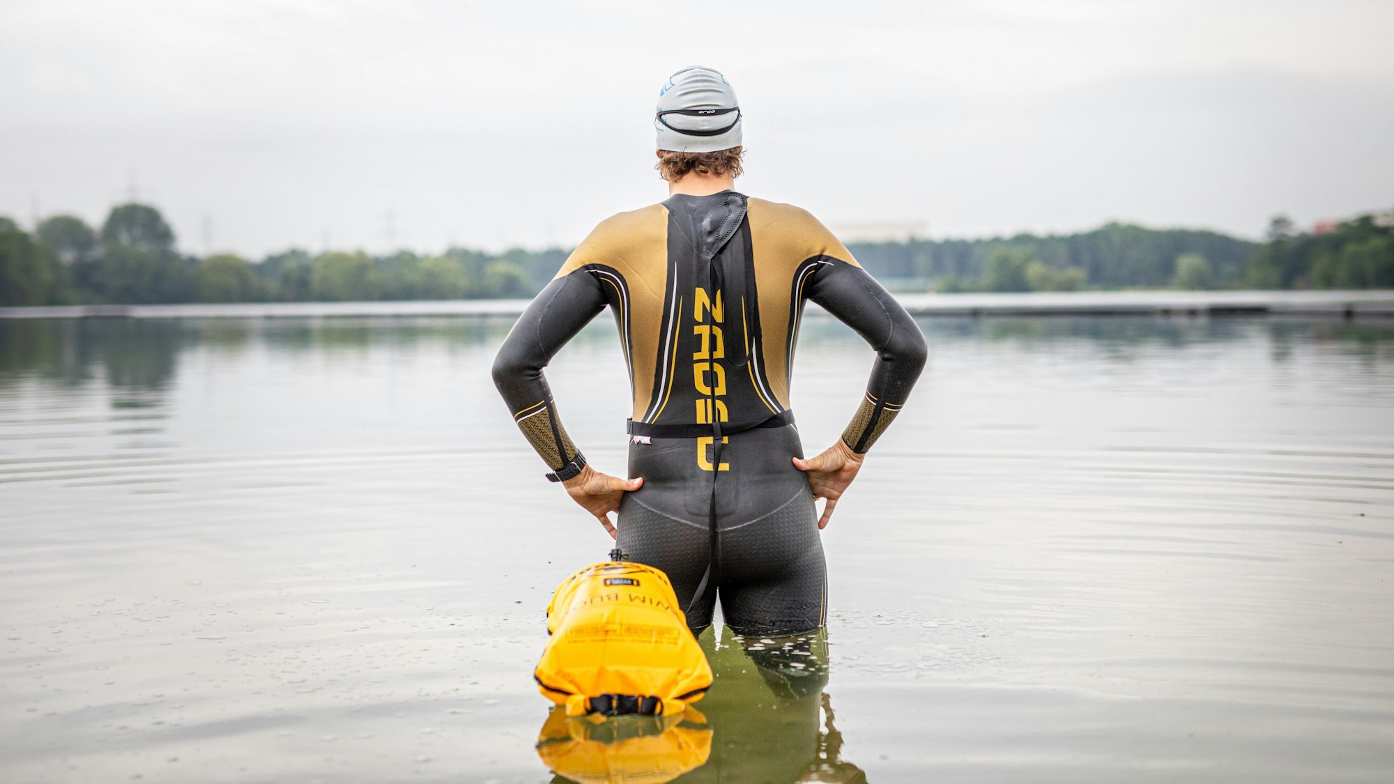 Der Schwimmtrainer und Athlet Johann Ackermann steht im Wasser am Ufer des Fühlinger See. Ackermann gibt unter dem Namen „Der Schwimmcoach“ regelmäßig Workshops für Triathleten, bei denen es um das Freiwasserschwimmen geht.