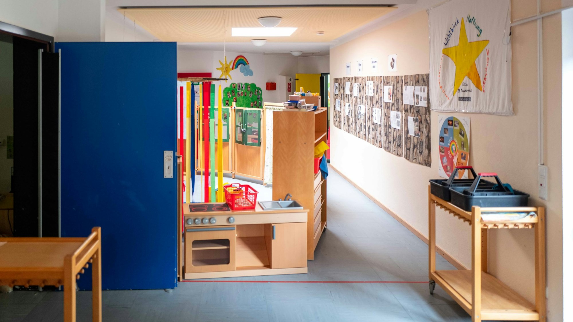 Das Bild zeigt den Flur des Kindergartens. Links steht eine Tür offen, die zu einem weiteren Raum führt.