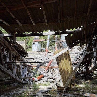 Eine Industrieruine ist die ehemalige Firma Ruhr KG bei Nettersheim. Das Bild zeigt den Blick in eine Werkshalle, deren Dach teilweise eingestürzt ist.