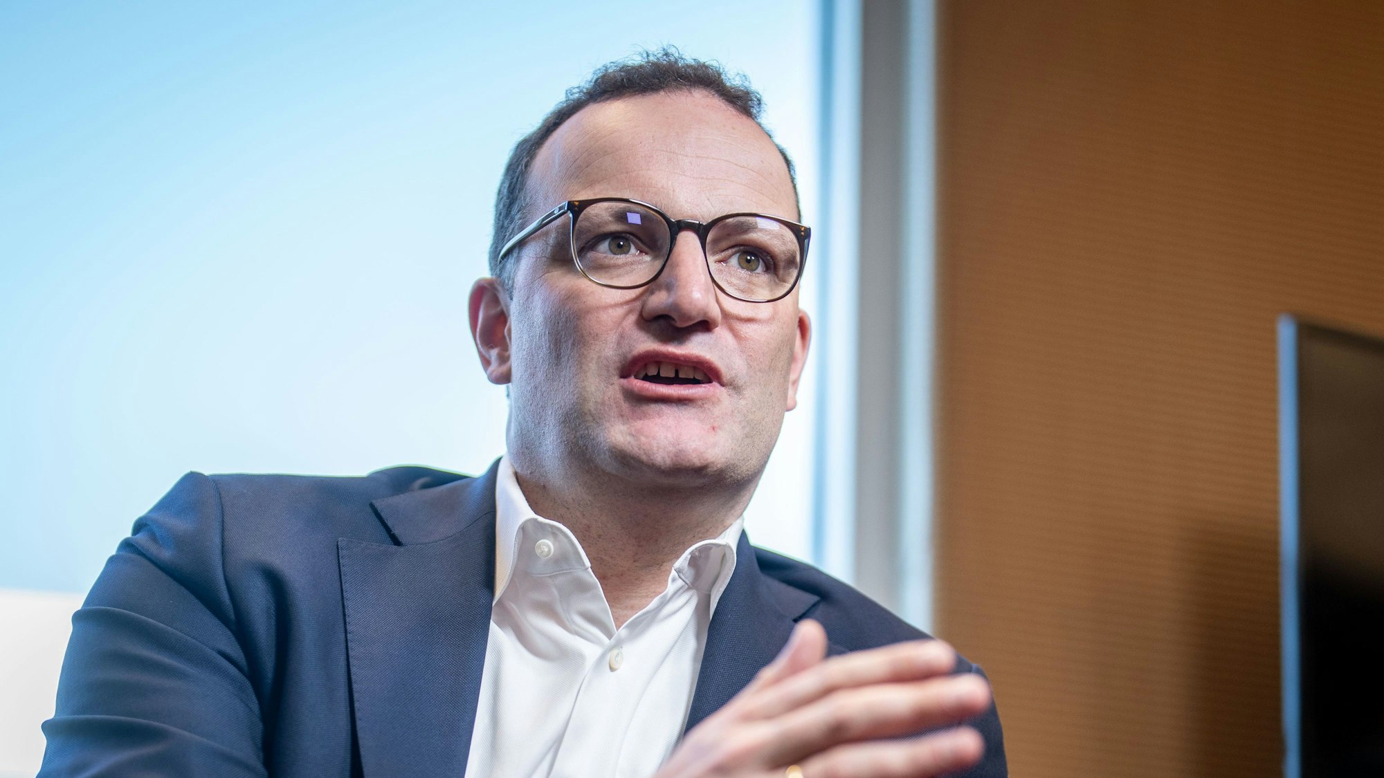 CDU-Politiker Jens Spahn sitzt im Bundestag und spricht während eines Interviews mit einem Gesprächspartner.